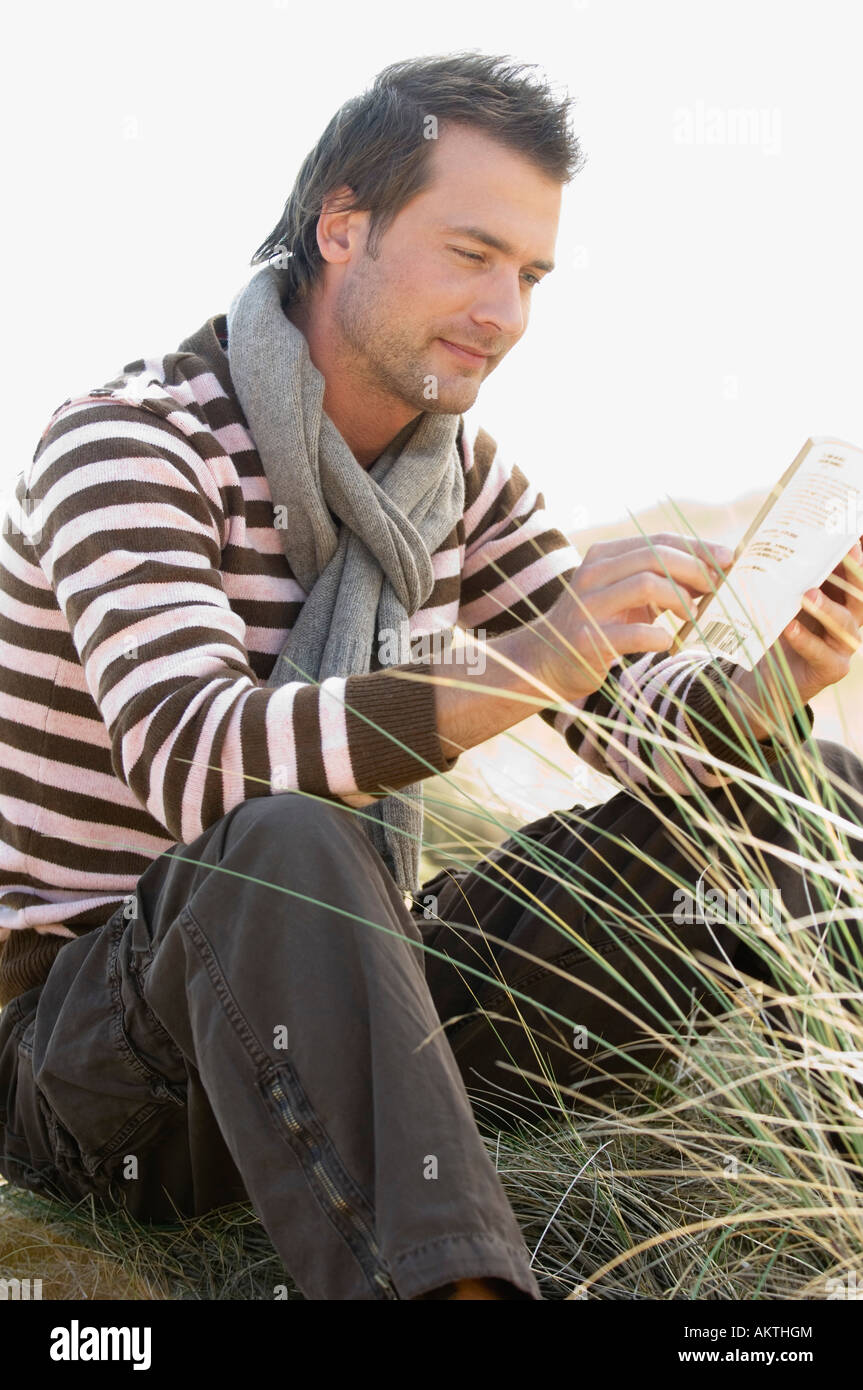 Mann liest ein Buch draußen, Seitenansicht Stockfoto