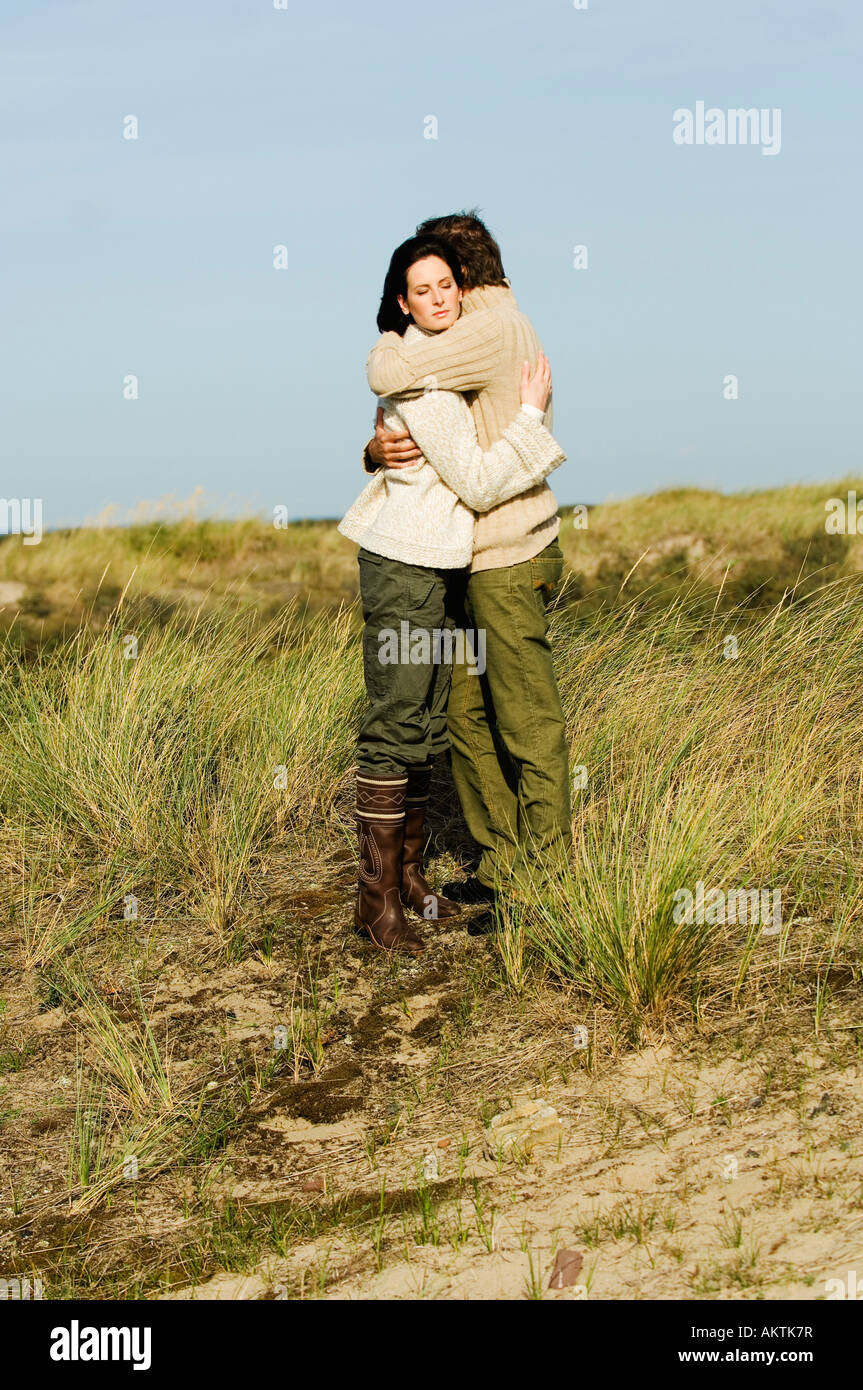 Junges Paar Stading auf Düne, umarmen Stockfoto
