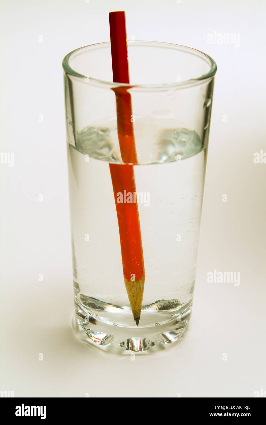 Ein Bleistift in ein Glas Wasser zeigt die optische Distoprtion, verursacht durch Brechung des Bildes Stockfoto