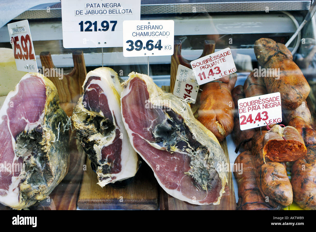 Perpignan Frankreich, kleiner lokaler französischer Metzgerladen, konservierte Lebensmittel Spanischer Schinken im Fenster, Lebensmittelpreise Stockfoto