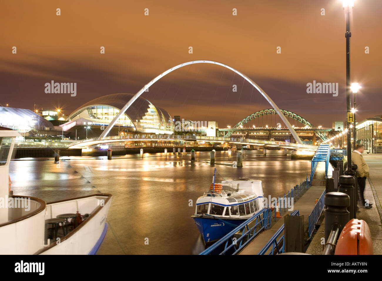 Newcastle-Gateshead-Kai in der Nacht. Zeigt die Sage Gateshead Millennium Bridge und Tyne Bridge Stockfoto