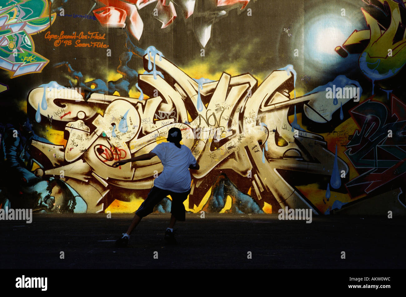 New York USA junge Ballspielen gegen Graffiti Wandmalerei in IS306 Schule Bronx Stockfoto