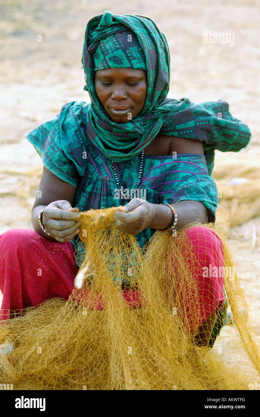 Eine Frau an den Ufern des Flusses Niger entfernt kleine Fische aus einem net Mali Stockfoto
