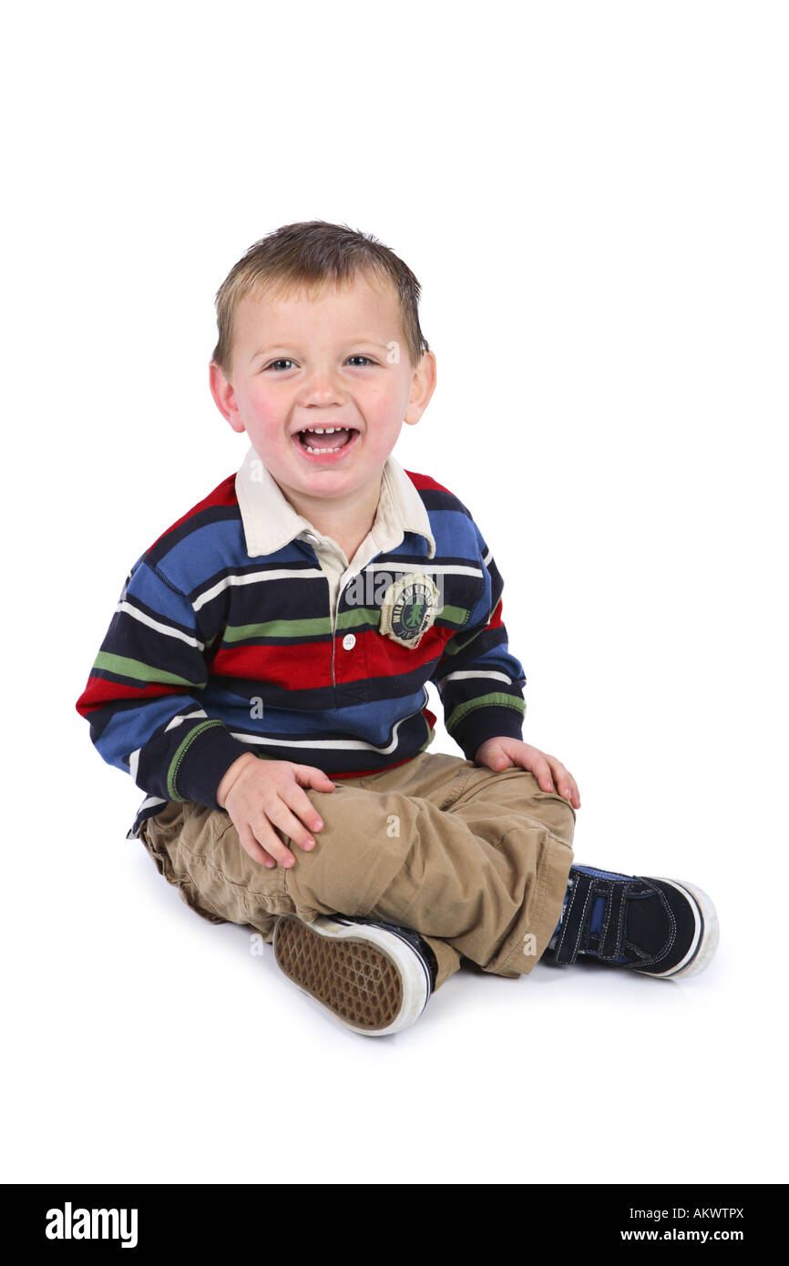 Zwei Jahre alter Junge sitzt ausgeschnitten auf weißem Hintergrund Stockfoto