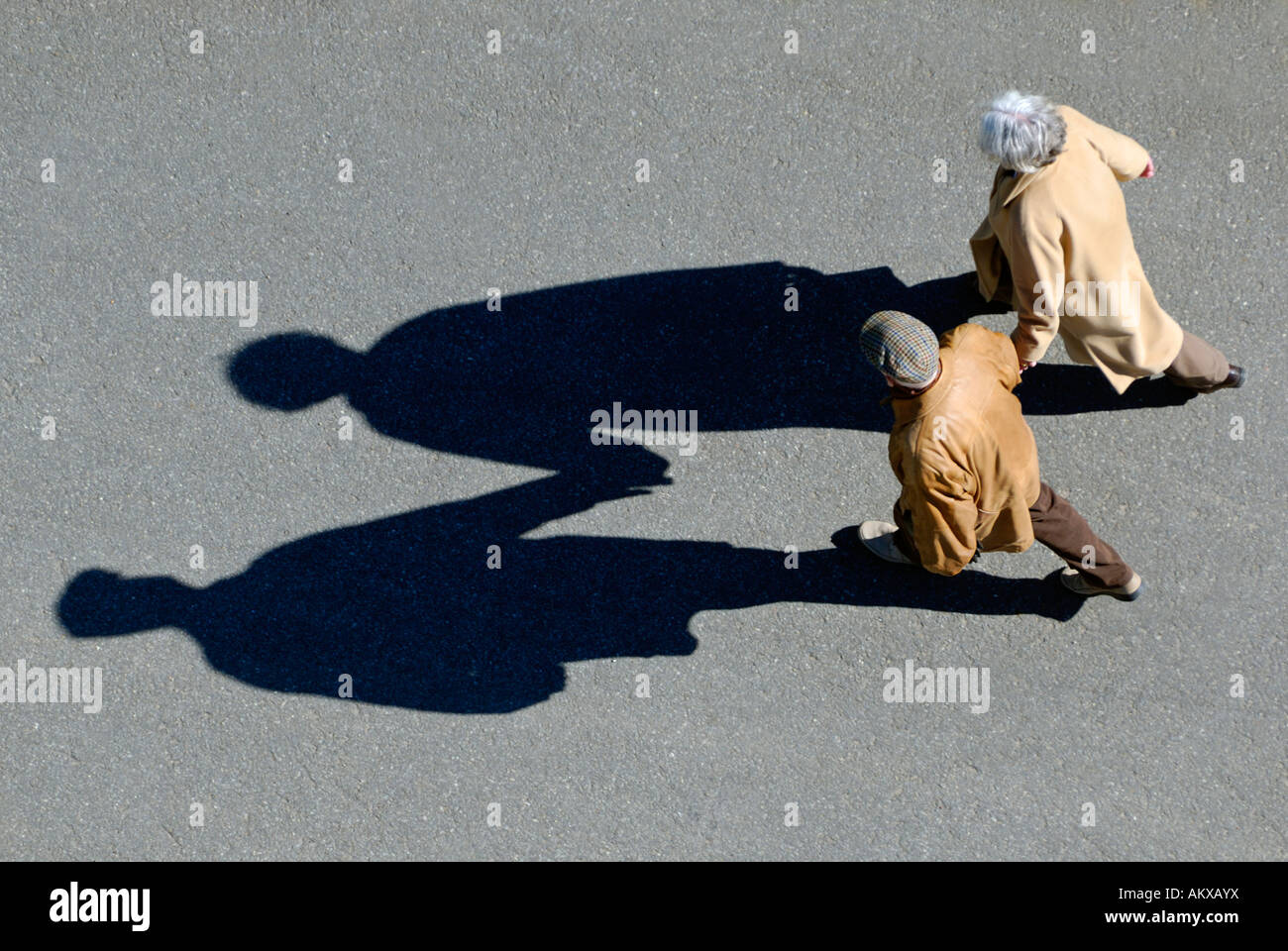 Seniorenpaar, die Hand in Hand gehen, Vogelperspektive mit Schatten Stockfoto