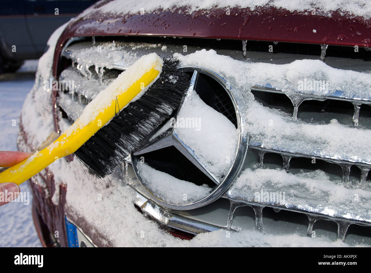 Ein Mercedes Benz Auto wird mit einem Besen aus Schnee und Eis