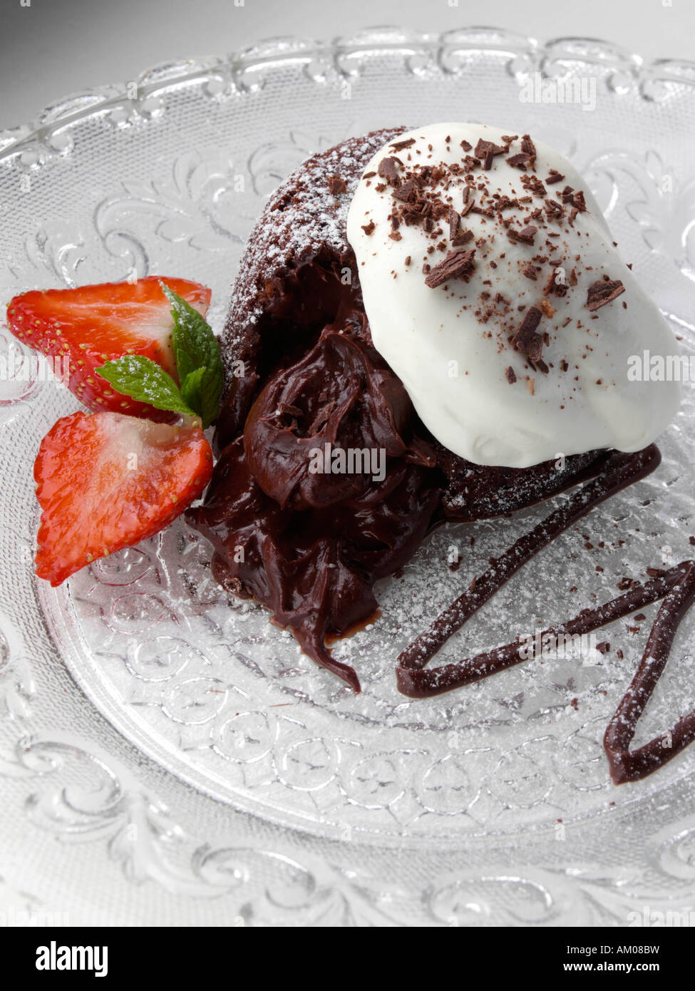 Schokoladen-Fondant-Pudding mit Erdbeeren und Sahne redaktionelle Essen Stockfoto