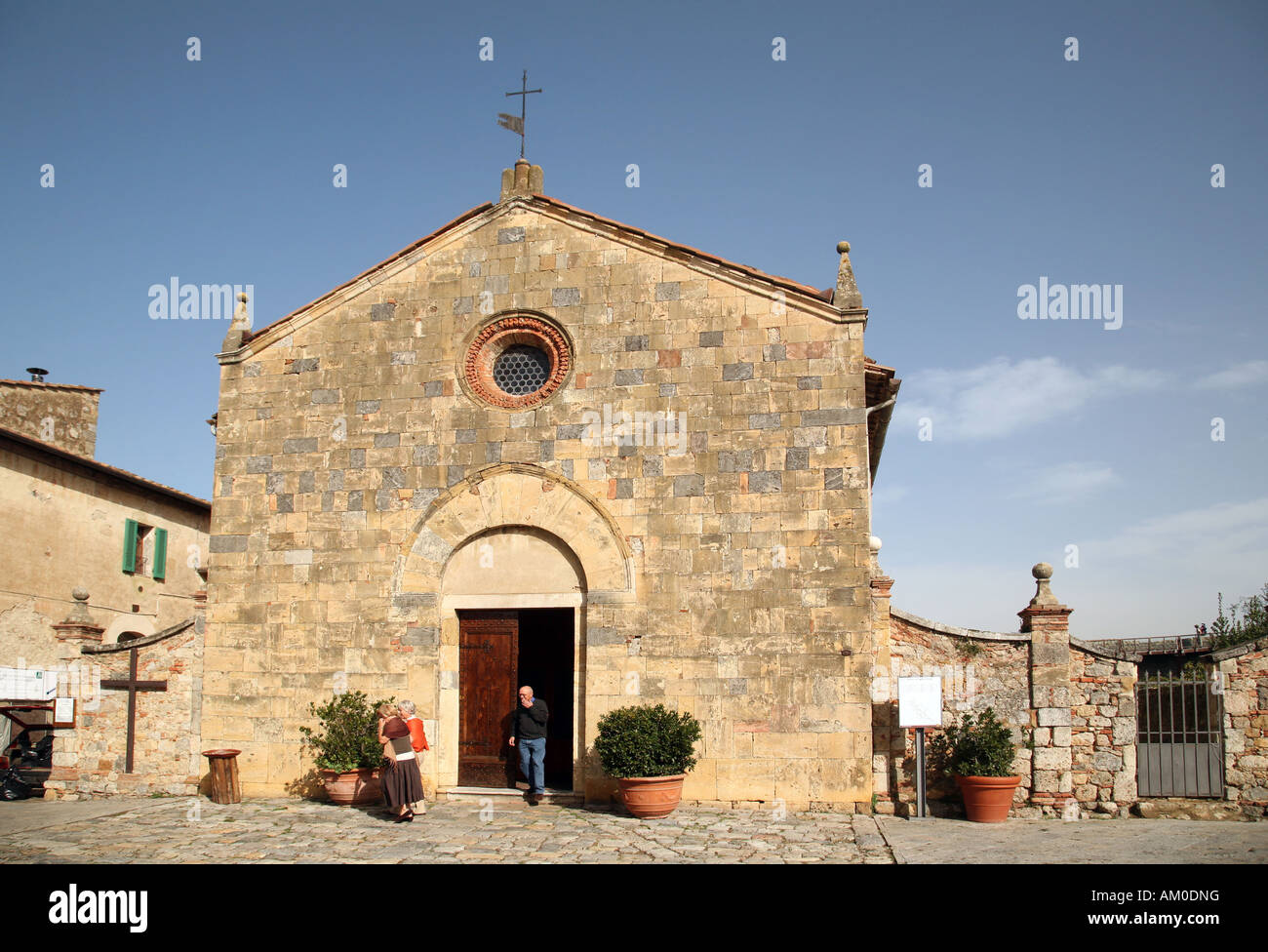 Menschen kommen aus der Kirche, Monteriggioni Toskana Italien Stockfoto