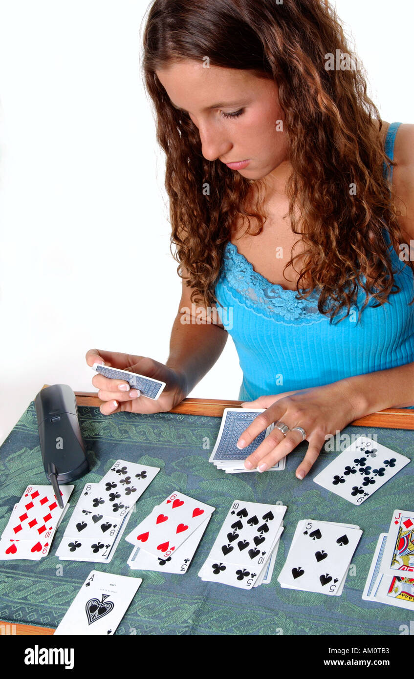 Kaukasische Teengirl spielt Solitär und wartet darauf, dass Freund nach Anruf, USA Stockfoto