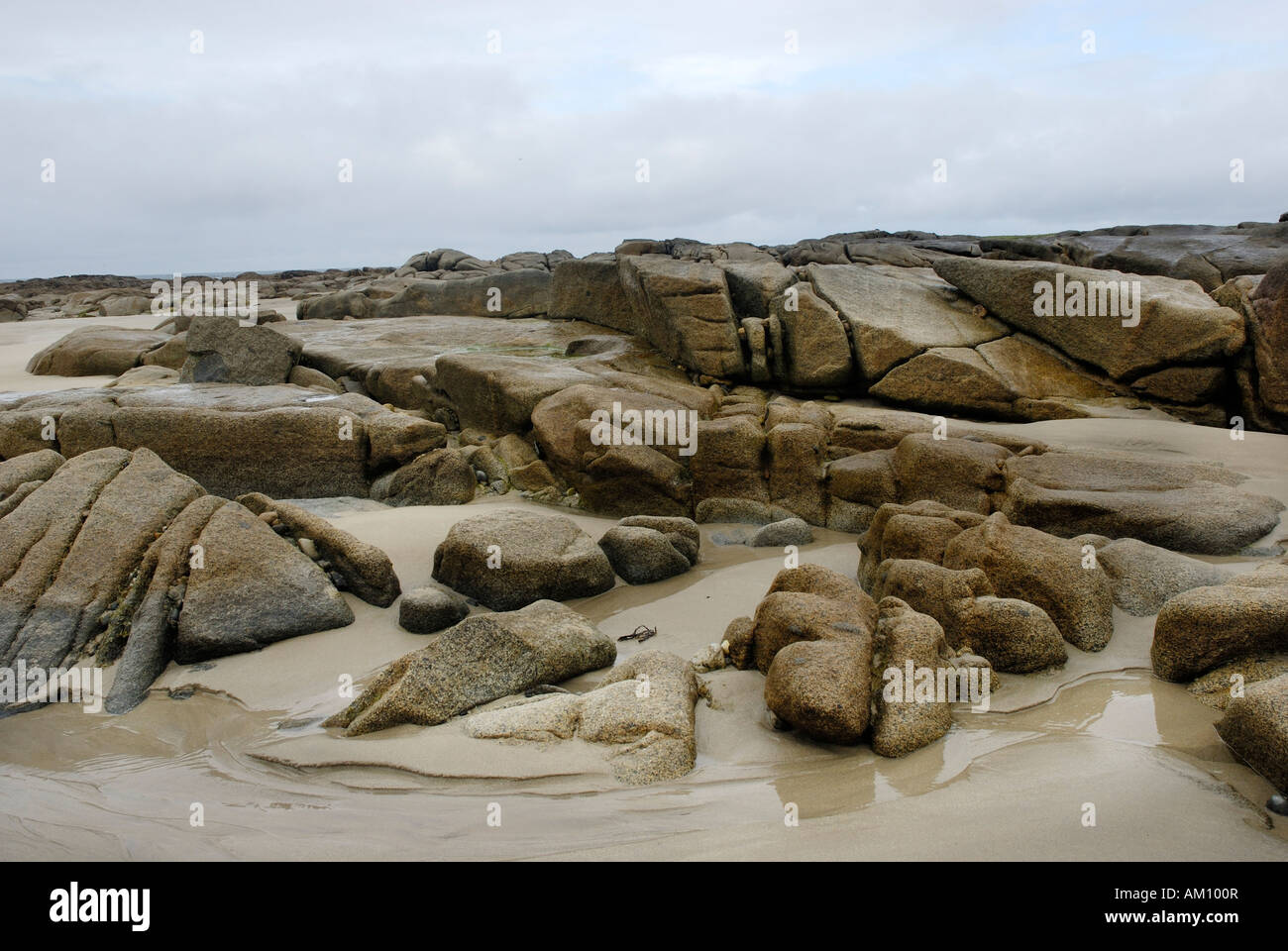 Granitfelsen in der Gezeitenzone der Sandstrand an der Altanic Küste von Donegal an einem nebeligen Tag, Irland Stockfoto