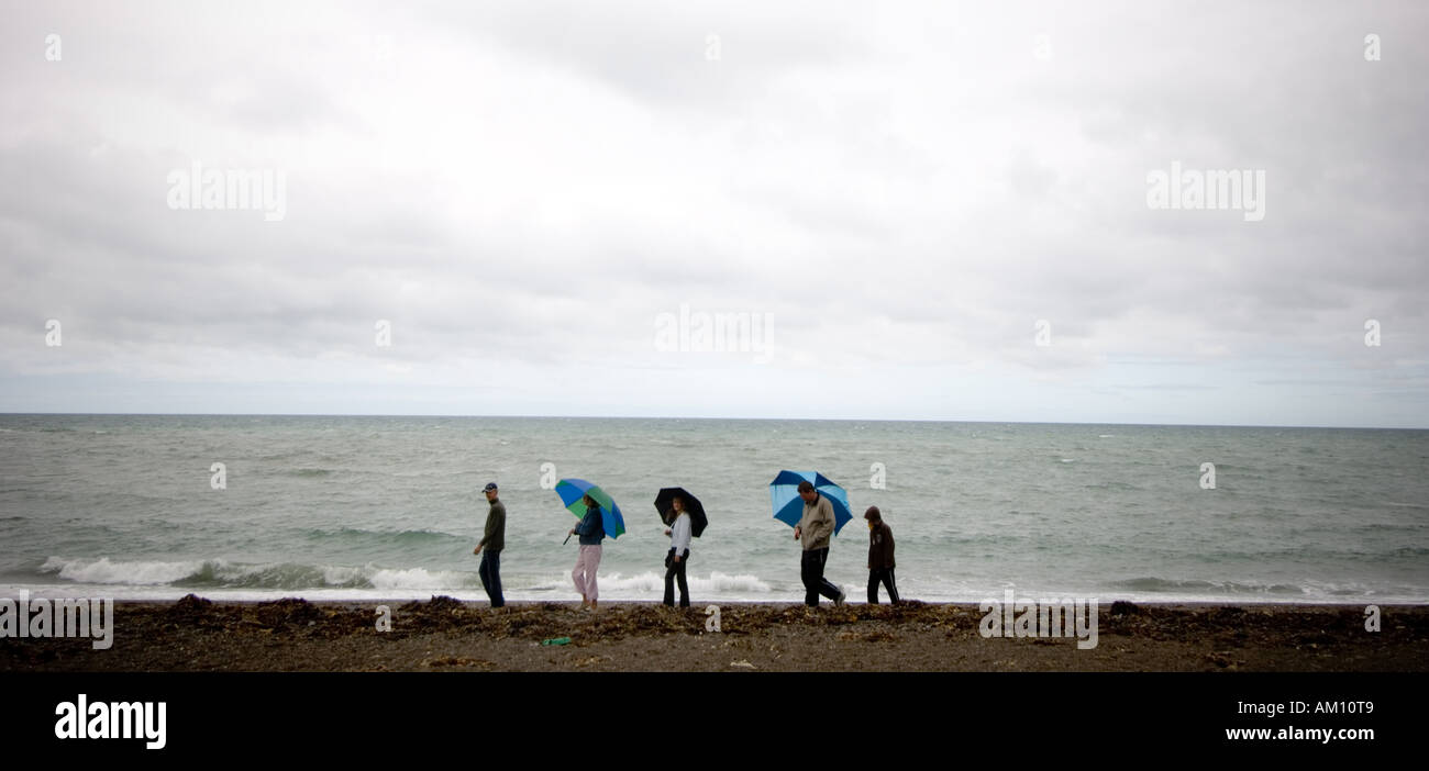 eine Familie zu Fuß am Strand in den Regen Sommer august Bank Holiday Wochenende Aberystwyth Ceredigion wales UK Stockfoto