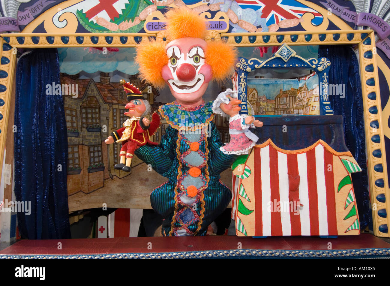 Joey der Clown hält zwei Miniatur-Punch and Judy Puppen in einen Punch and Judy stand, UK Stockfoto