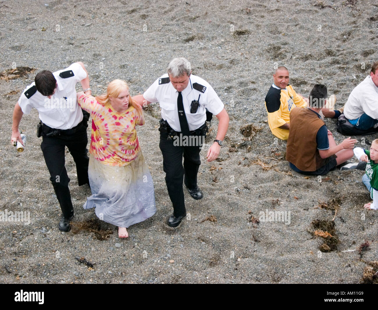 Polizei eine Frau verhaften und Durchsetzung eines Alkoholverbots trinken in der Öffentlichkeit am Strand Aberystwyth Ceredigion Wales UK Stockfoto