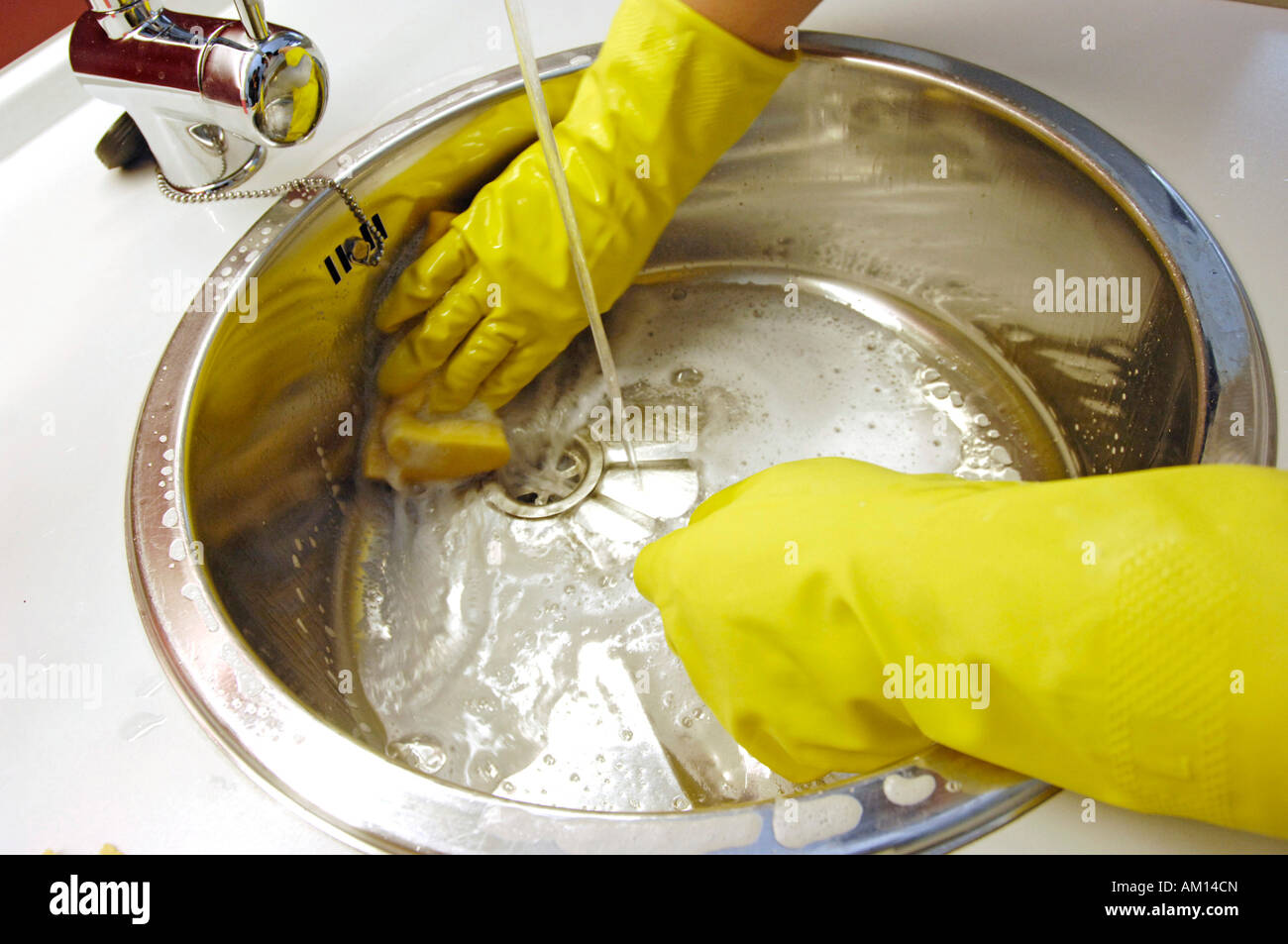 Reinigung eine Waschbecken mit Handschutz Stockfoto