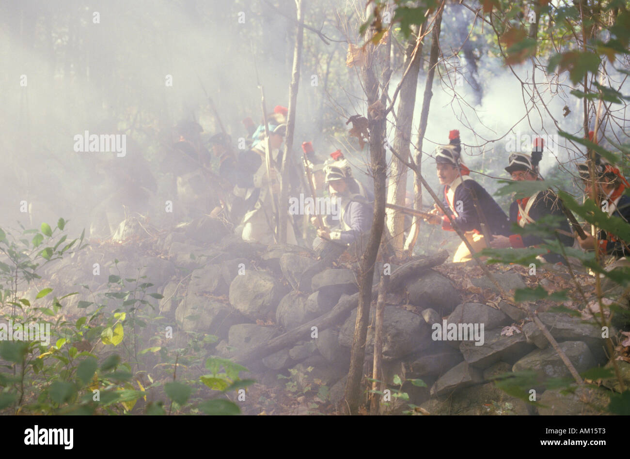 Im 18. Jahrhundert amerikanische militärische Tracht gekleidete Männer Feuer Musketen und Aufladen durch Nebel während einer Schlacht des Unabhängigkeitskrieges Stockfoto