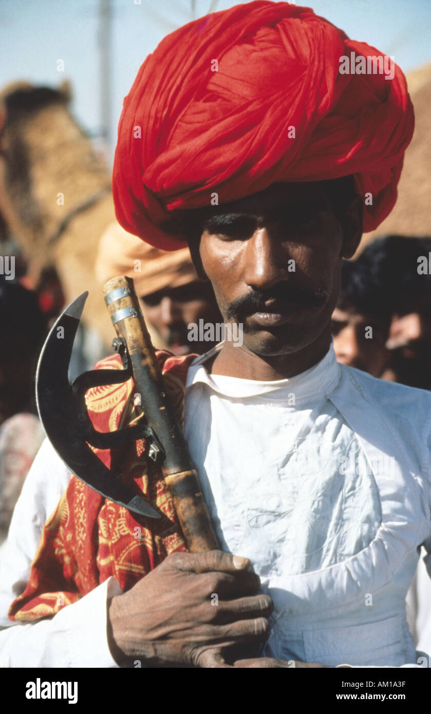 Indischen Rajasthan Wüste tribal Mann mit wunderschön gebundenen roten Turban und eine Axt. Stockfoto