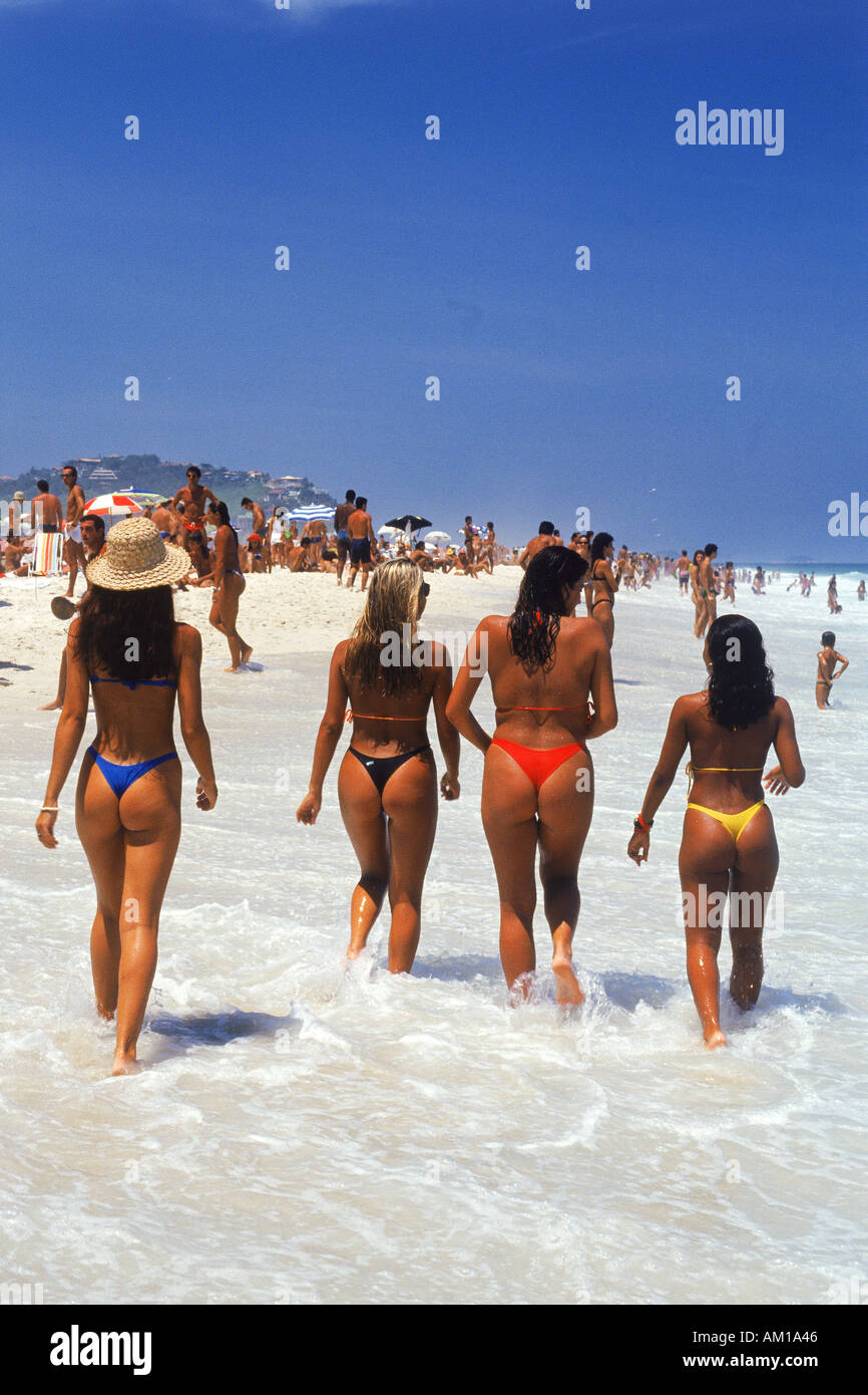 Vier junge Frauen in Bikinis zu Fuß entlang der Strand von Ipanema in Rio de Janeiro Stockfoto