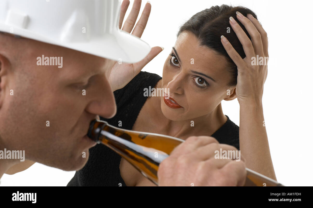Ein Arbeiter ist Bier zu trinken und die Frau ist wütend darüber Stockfoto