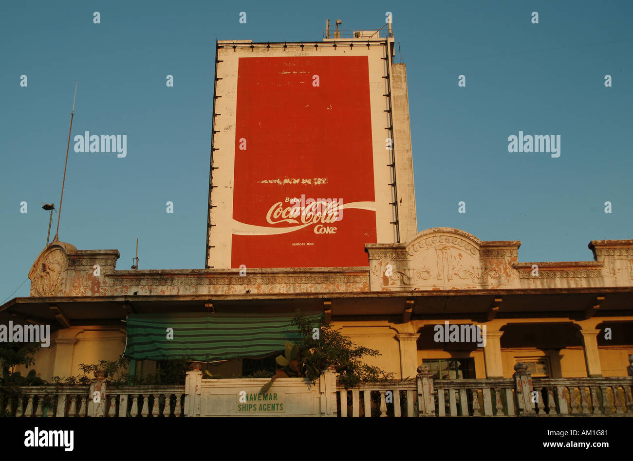 Neue und alte Kontrast von kolonialer Architektur und Globalisierung. Coca Cola Plakat erhebt sich über alte Gehäuse. Maputo, Mosambik Stockfoto