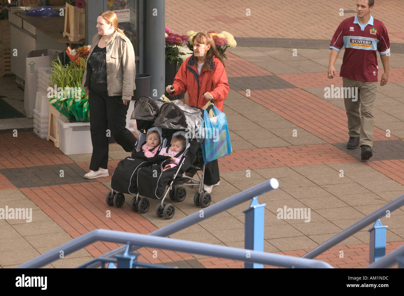 Mutter, Großmutter und Zwillingstöchtern im Doppel Kinderwagen in Burnley Einkaufszentrum Lancashire Stockfoto