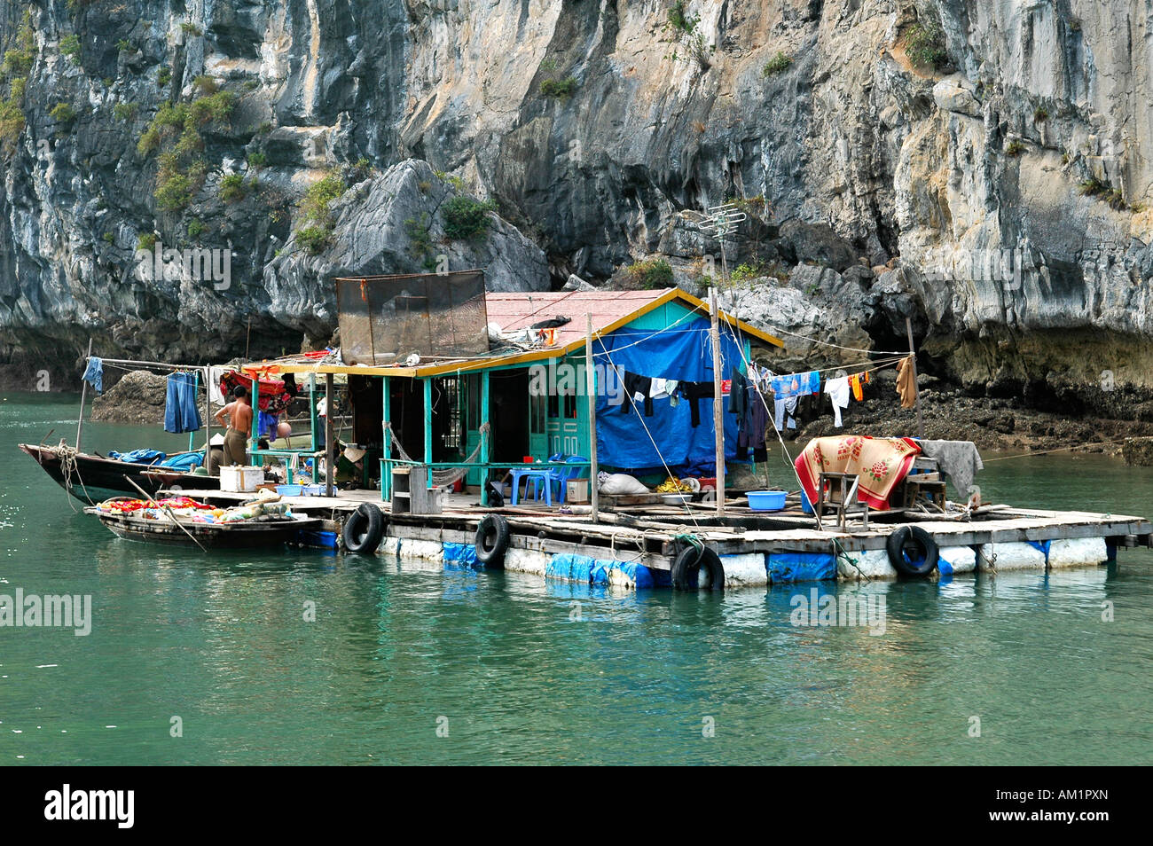 Künstliche Insel für die Aquakultur vor monolithischen Kalksteininsel der Halong Bucht, Vietnam Stockfoto