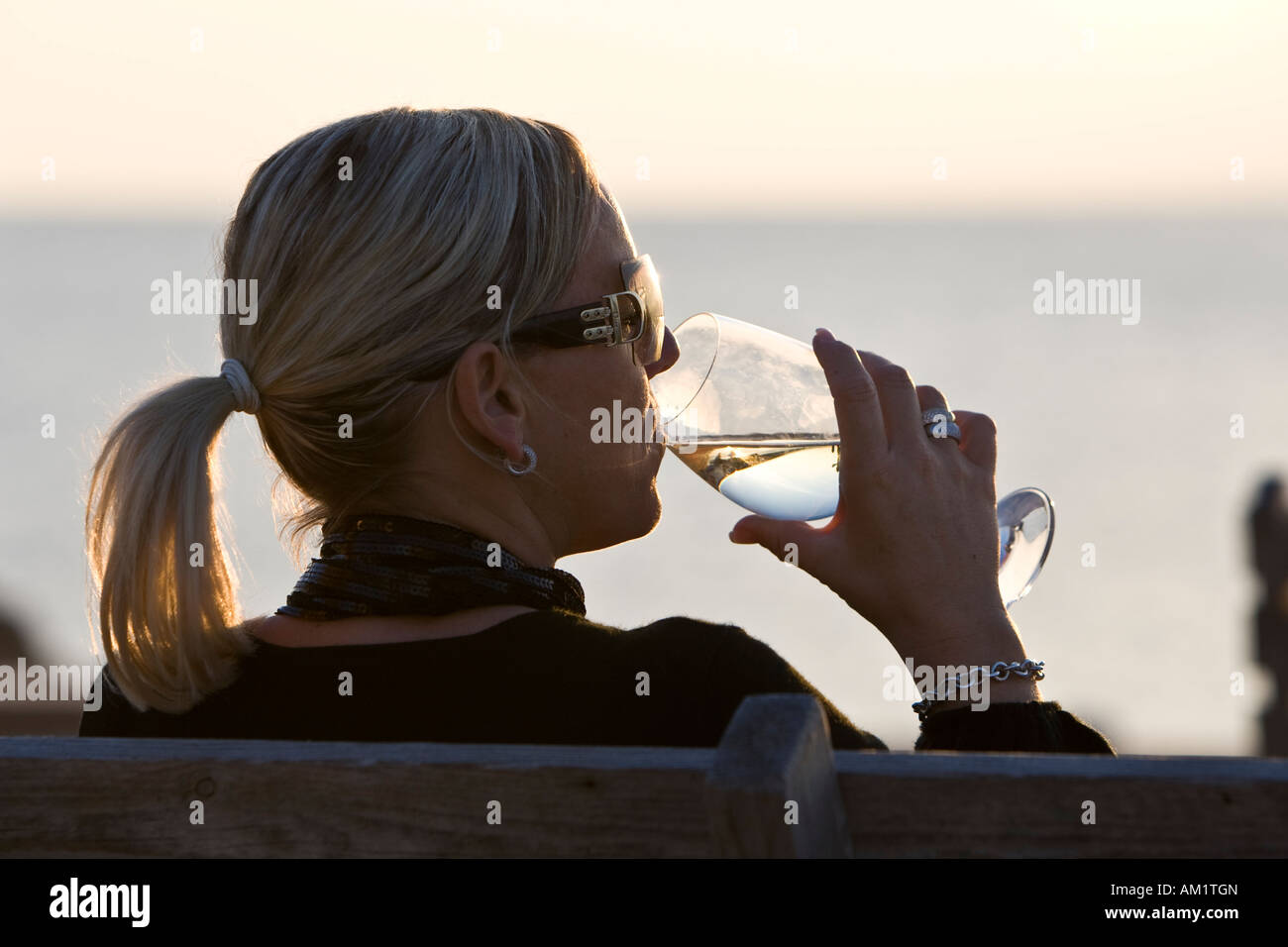 Frau trinkt Wein am Cap de Falco, Ibiza, Balearen, Spanien Stockfoto