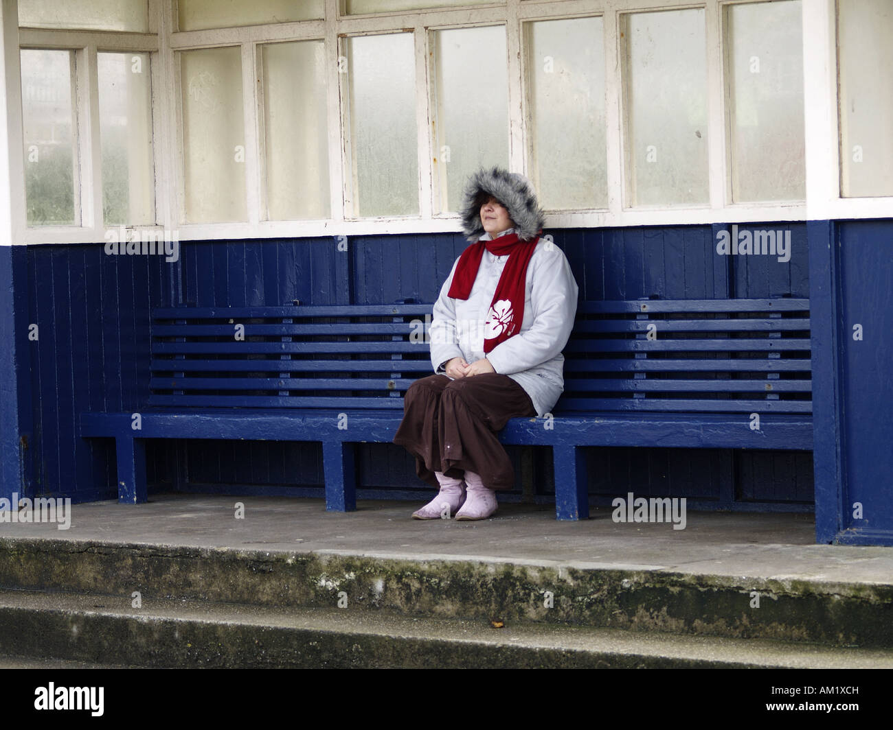 Frau saß im Tierheim am Meer Westward Ho North Devon 27. November 2007 Stockfoto