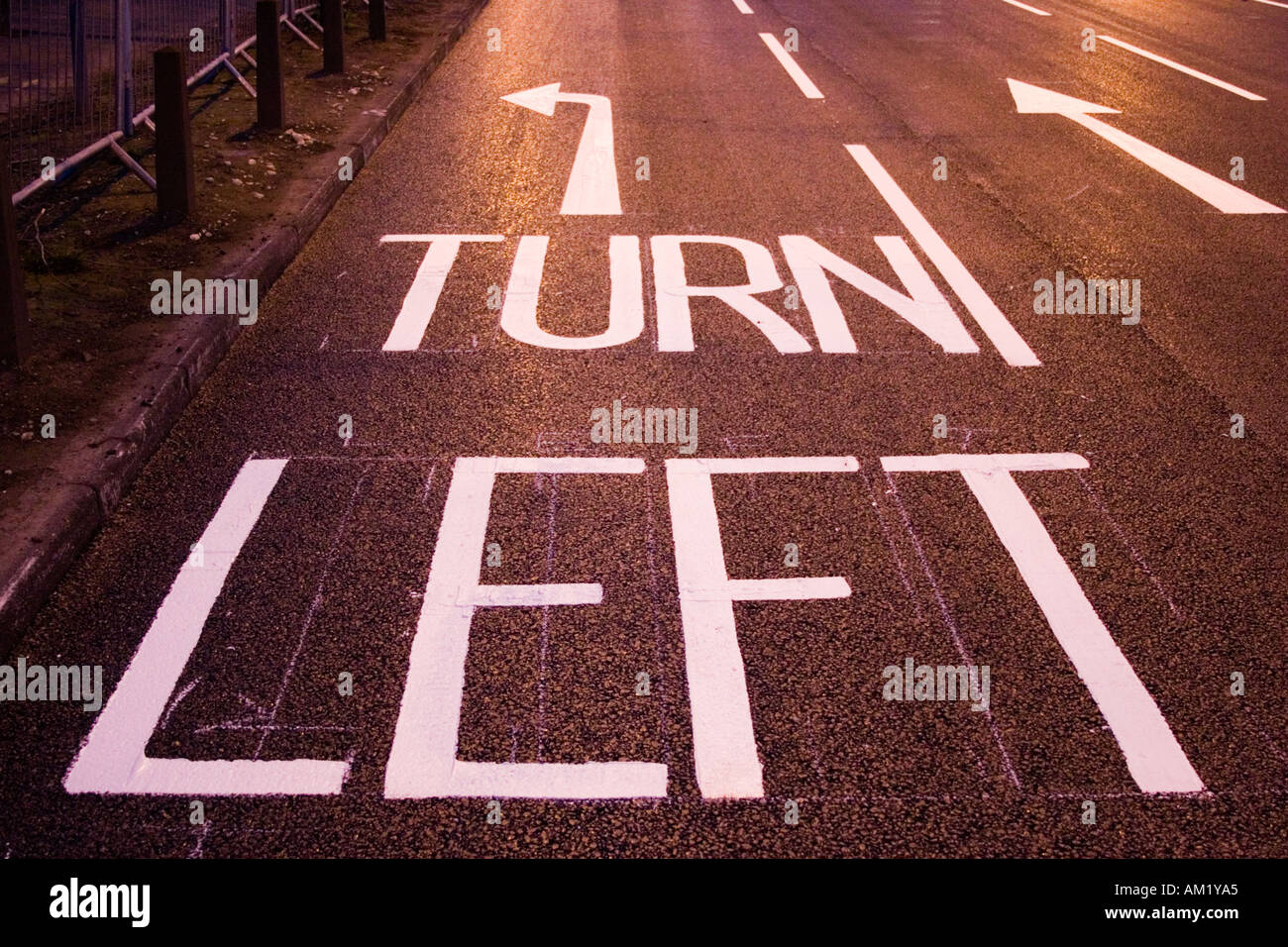 nächtliche Straße Szene geschrieben Straßenmarkierungen links abbiegen Stockfoto