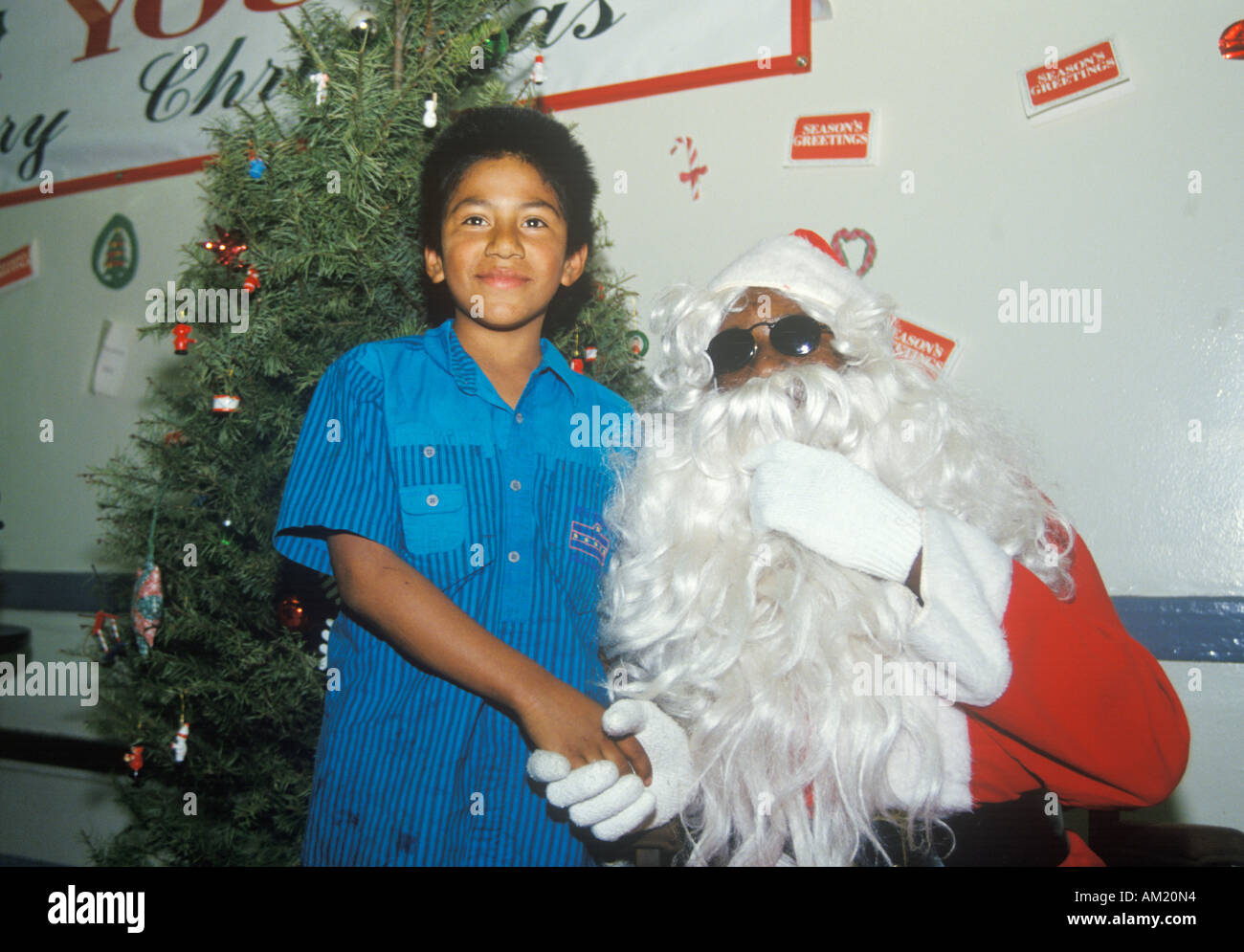 Afrikanische amerikanische Weihnachtsmann mit mexikanischen American Boy-Los Angeles-Kalifornien Stockfoto