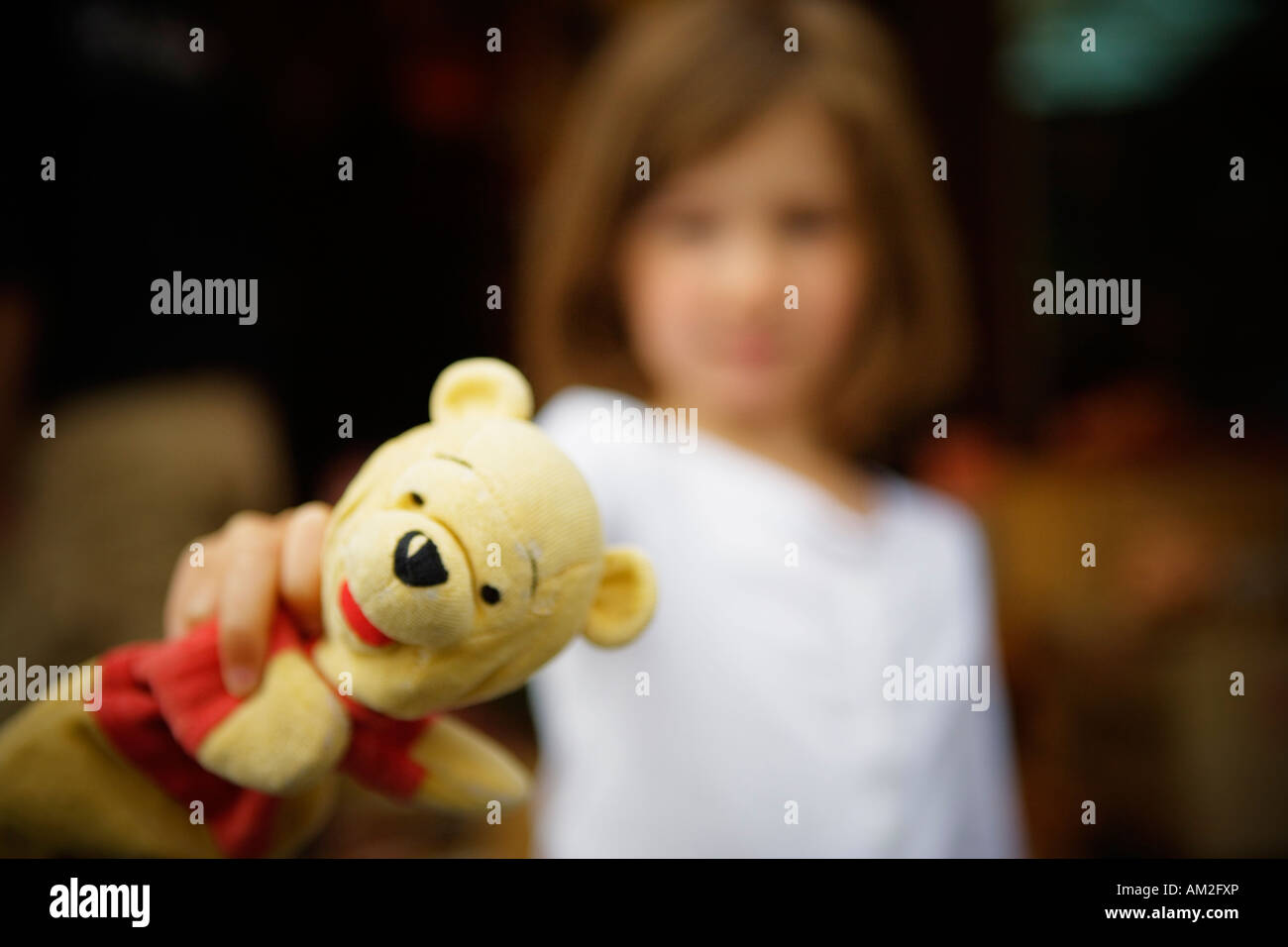 kleines Mädchen hält ein Winnie The Pooh und zeigte in der Kamera