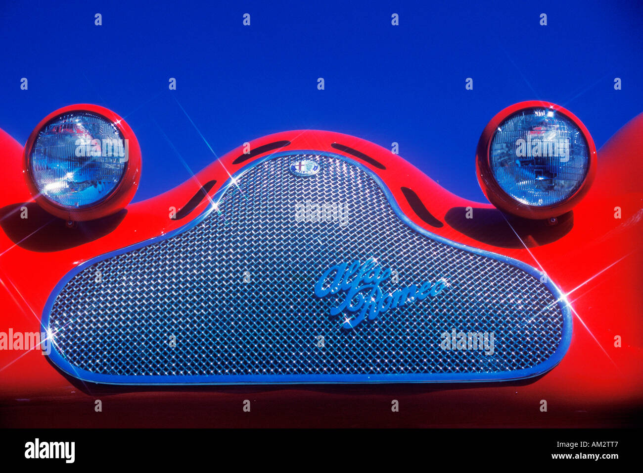 Eine Detailansicht einer hochglanzpolierten Chrom Grill und Fehler eyed Scheinwerfer auf einem roten Alpha Romeo Sport Oldtimer Stockfoto