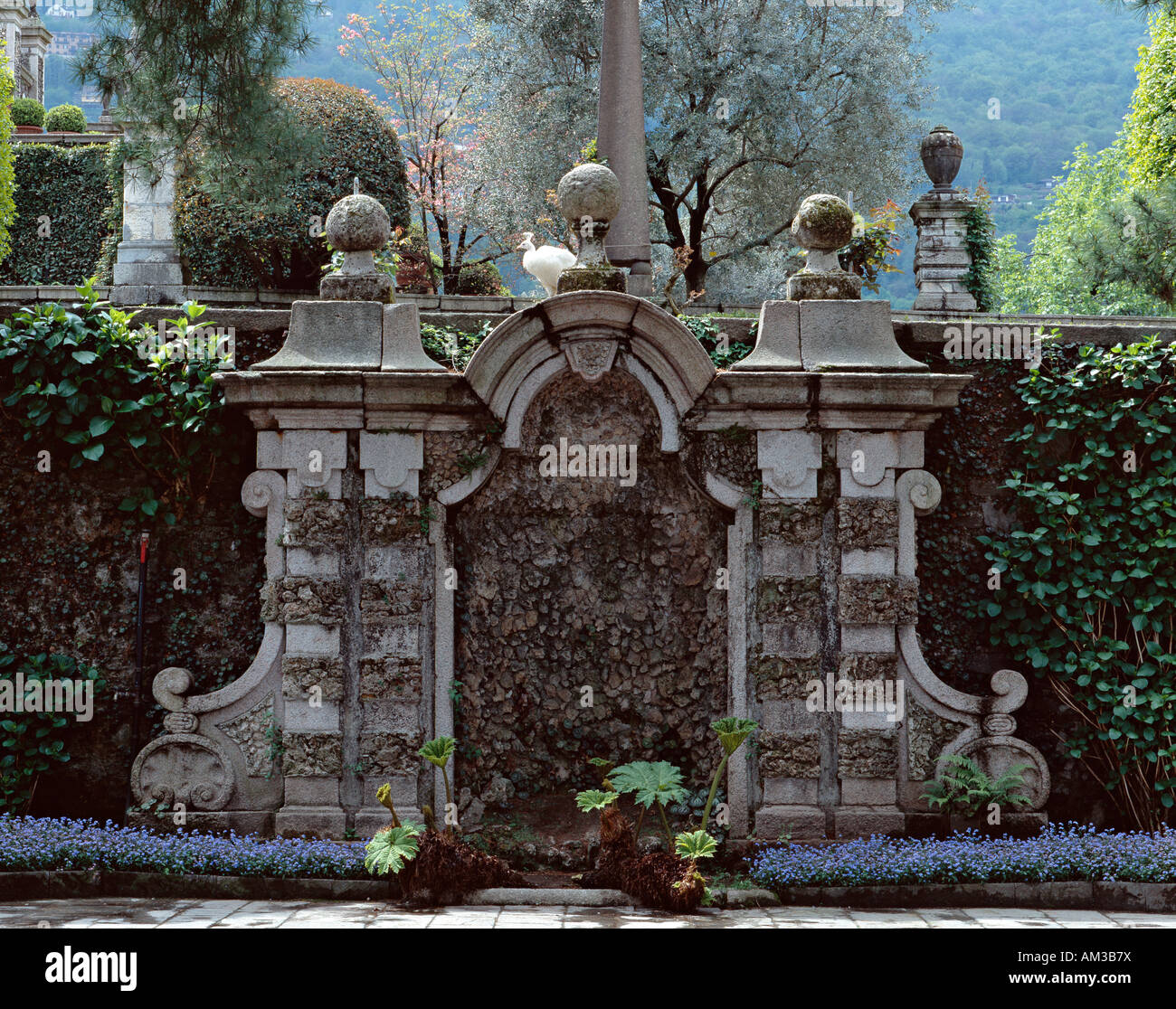 Die romantische Insel garten Isola Bella, Lago Maggiore, Italien. Ein Detail der Gärten mit einem der berühmten weißen Pfauen auf der Insel im Hintergrund Stockfoto