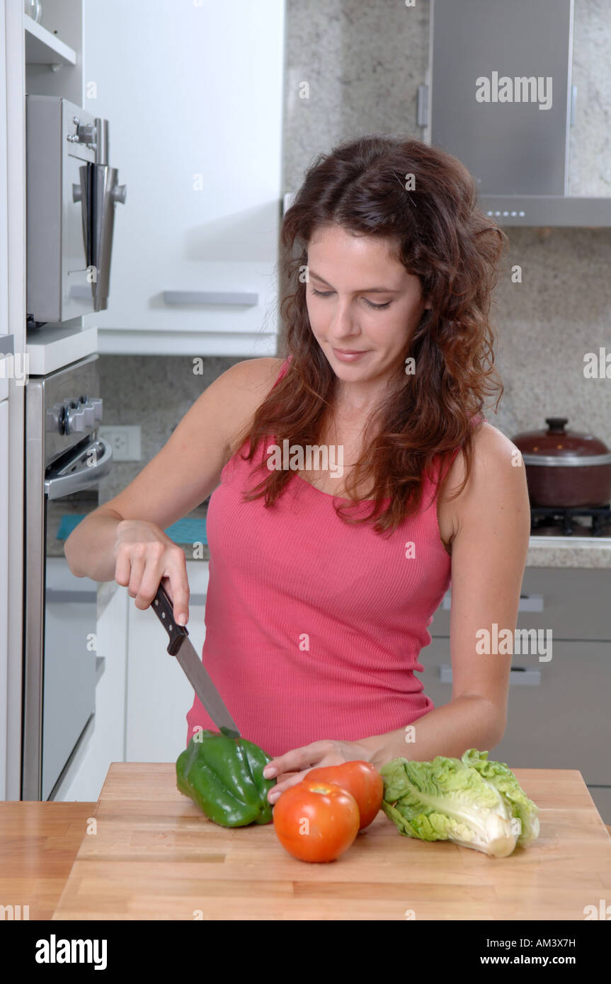 Junge Frau Hacken Gemüse in einer Küche Stockfoto