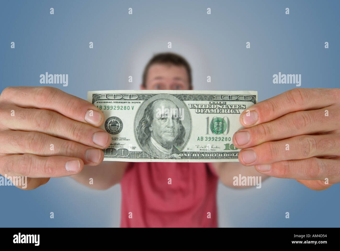 Mann hält eine 100-Dollar-Rechnung Stockfoto