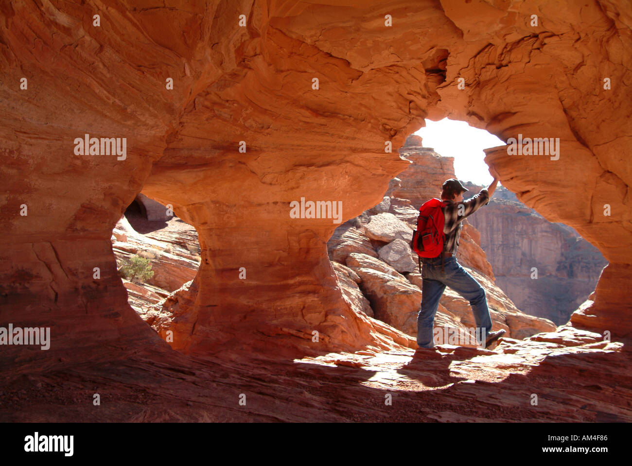Eine Frau Wanderer in Arizona Kollegen, von einer Klippe Höhle Stockfoto