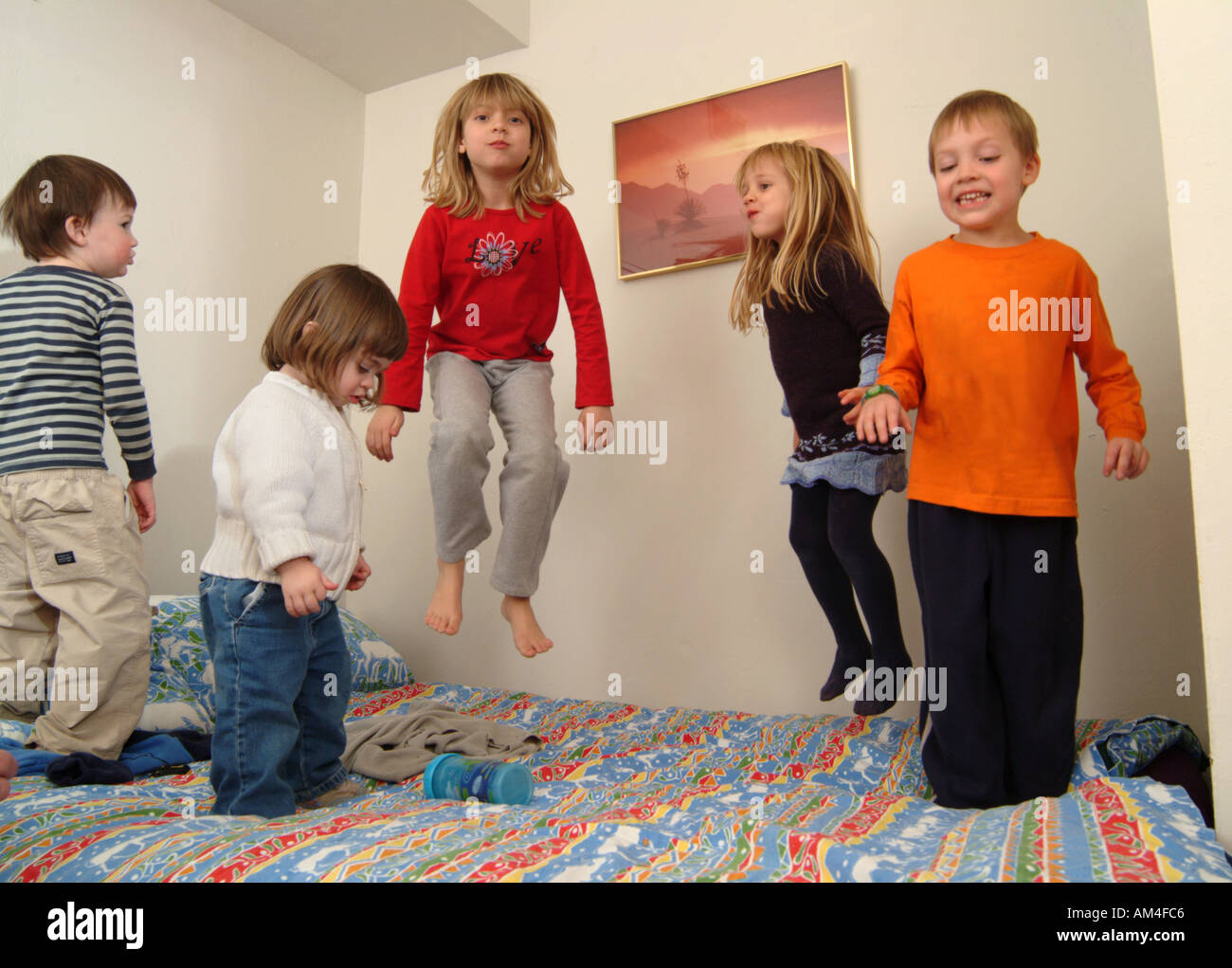 jungen und Mädchen spielen in ihrem Zimmer auf dem Bett springen Stockfoto