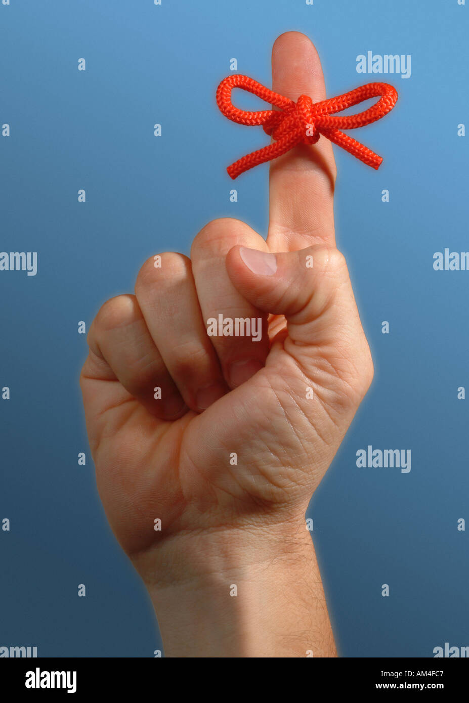 roter String am Finger gefesselt in einem großen Bogen als Erinnerung Stockfoto