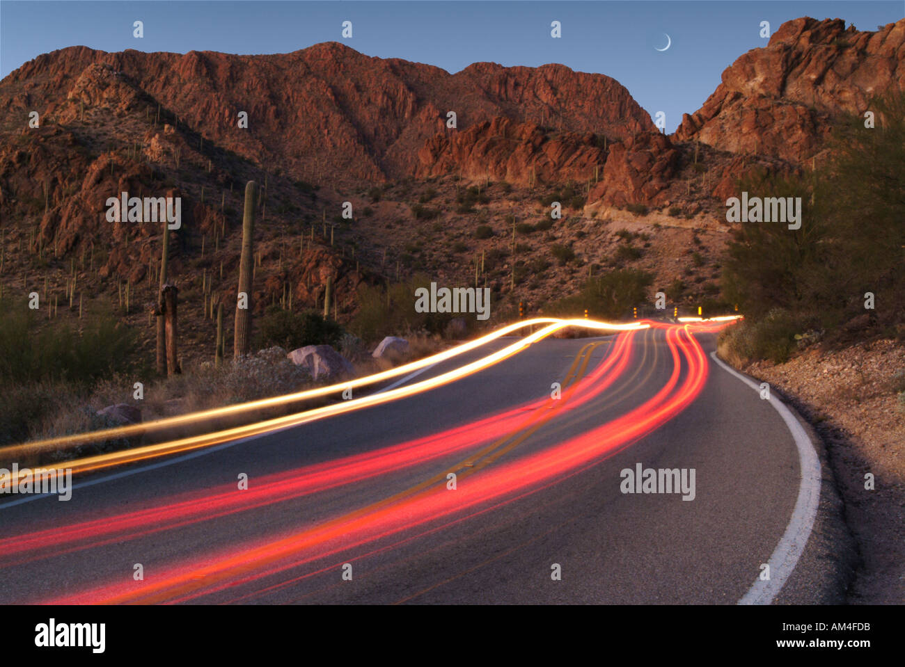 Lichtspuren von Autos auf einer einsamen Straße in Arizona. Dies ist Gates Pass in Tucson Stockfoto