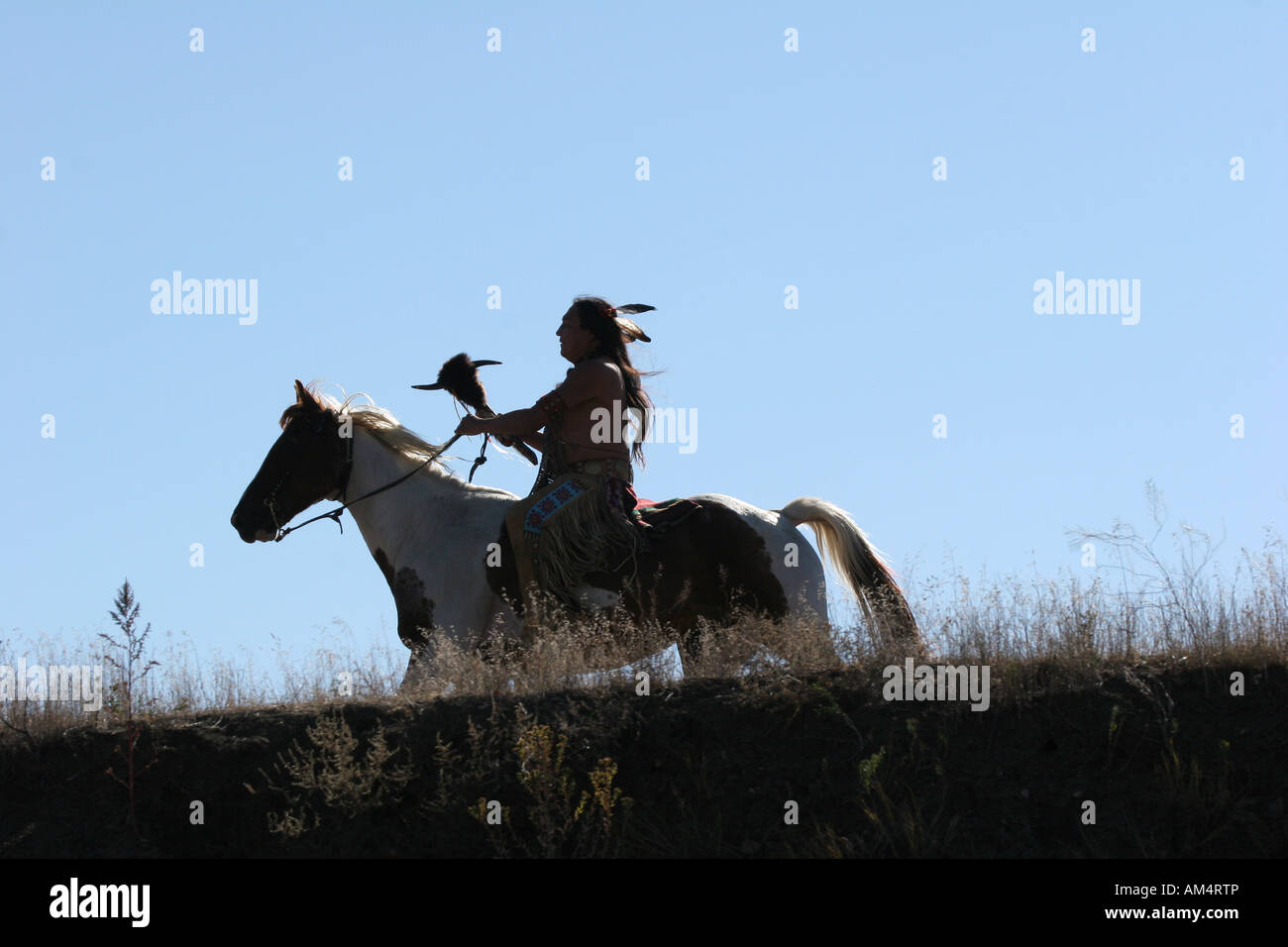 Eine Native American Indian Reiten Reiten auf der Suche nach Ememies durch die Prärie von South Dakota Stockfoto