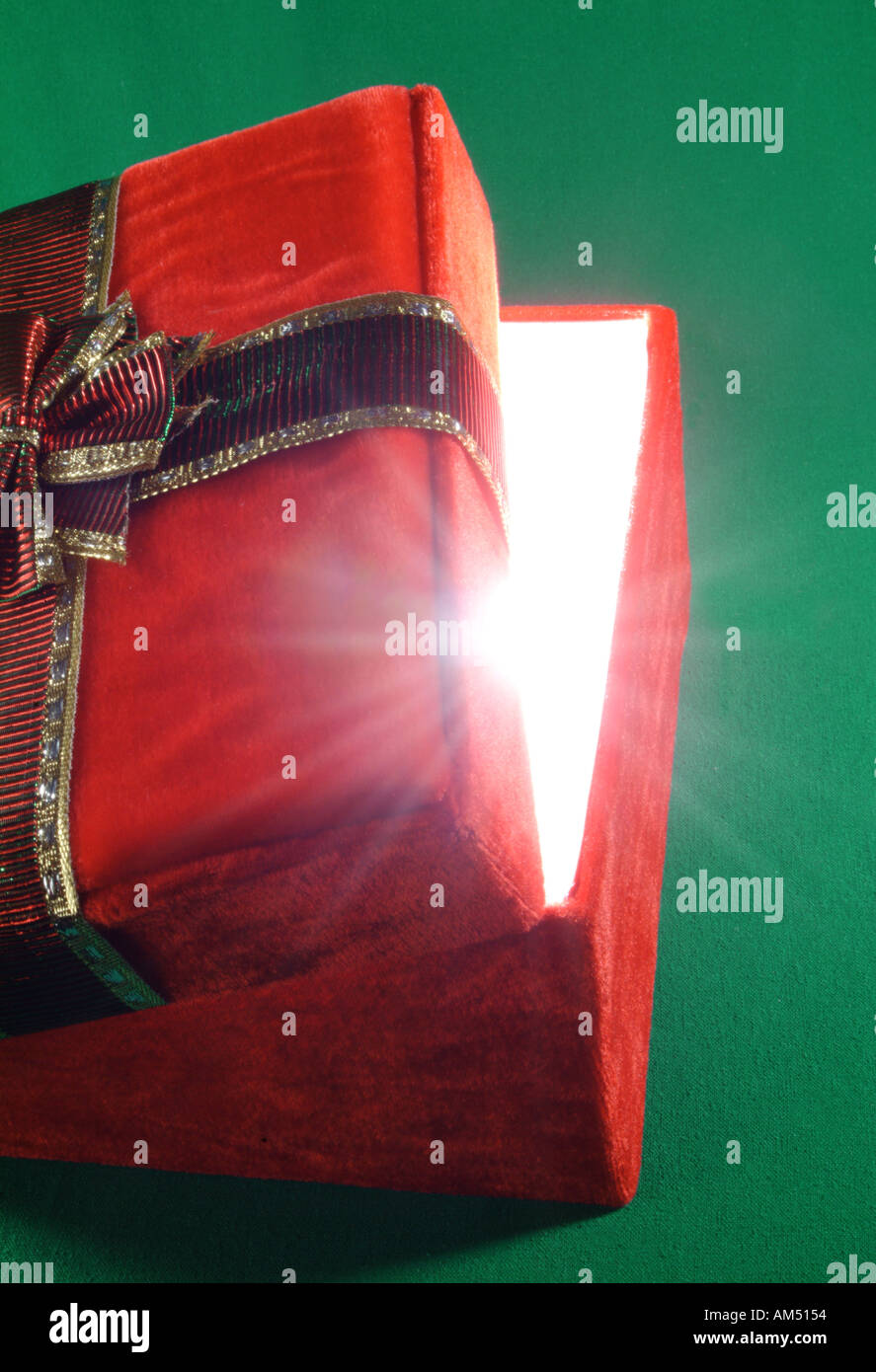 roten Geschenk-Box mit Deckel einen Spalt offen und Lichtstrahlen platzen Stockfoto