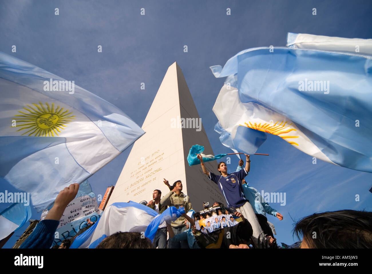 Argentinische Fußballfans singen unter dem Obelisken in Buenos Aires die wehenden argentinischen Flaggen. Plaza de la Republica. Stockfoto