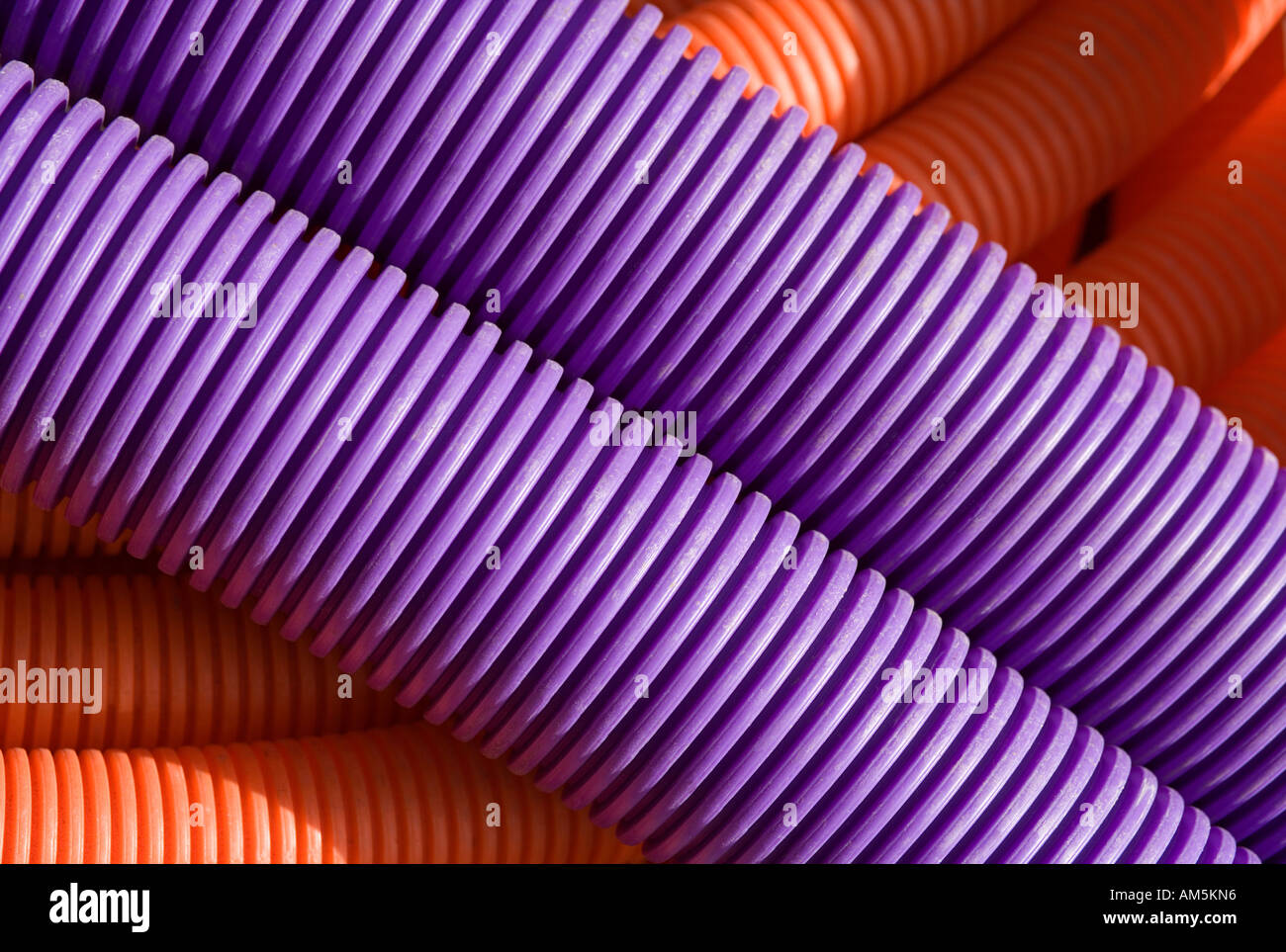 Flexible lila und orange Wellpappe Mantel Rohr Rohr Kabelspulen. Schlauch verwendet als Kanal für high-Speed-Kabel und Glasfaser LWL Stockfoto