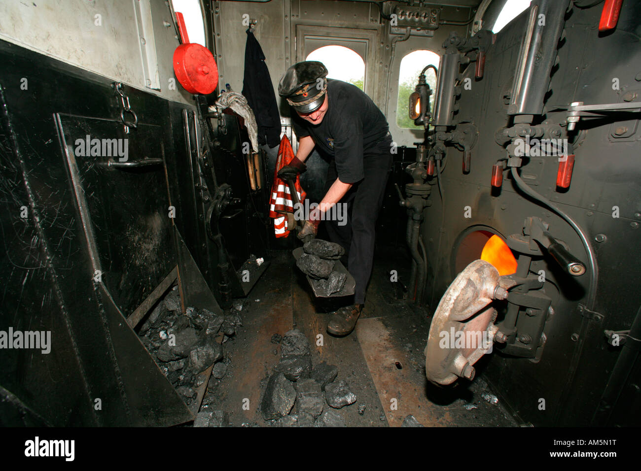 Lokführer, die Betankung des Tanks in einem historischen Dampfzug Stockfoto