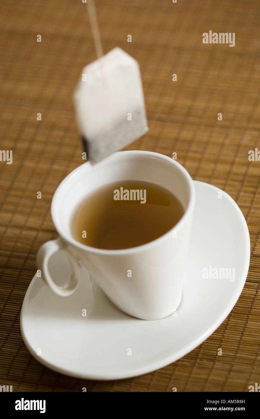 Nahaufnahme einer Tasse Kräutertee auf eine Untertasse mit einem Teebeutel Stockfoto