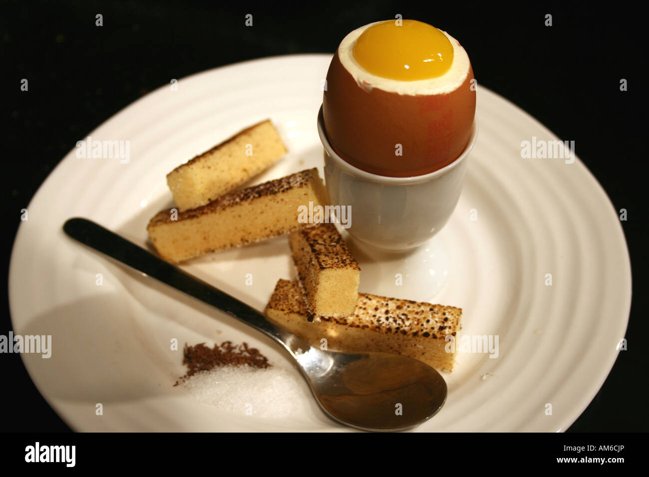 Gekochtes Ei mit Soldaten, Löffel, Salz und Pfeffer mit einem Eierbecher und Platte. Stockfoto