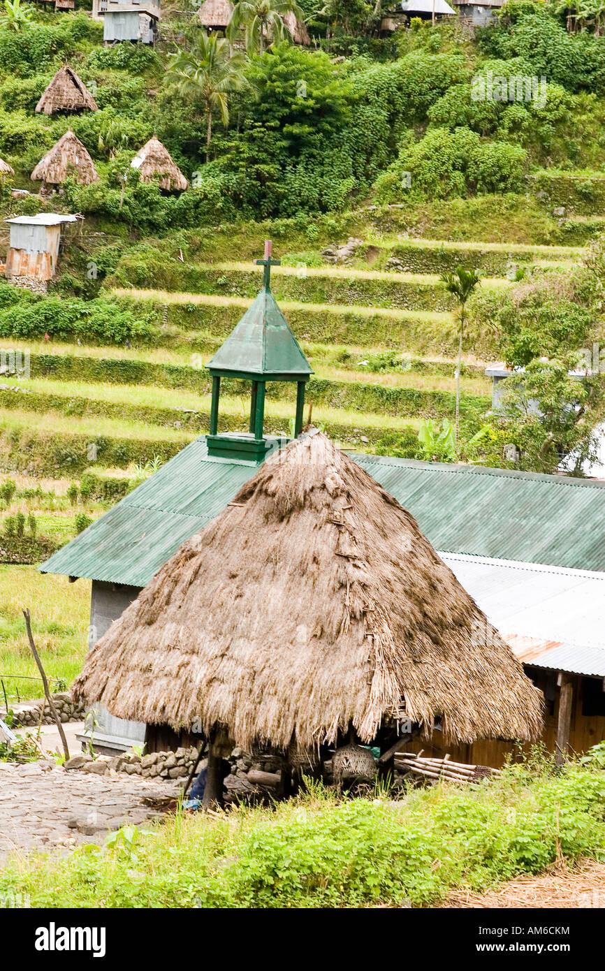 Eine Igorot-Hütte neben einer Kirche Stockfoto