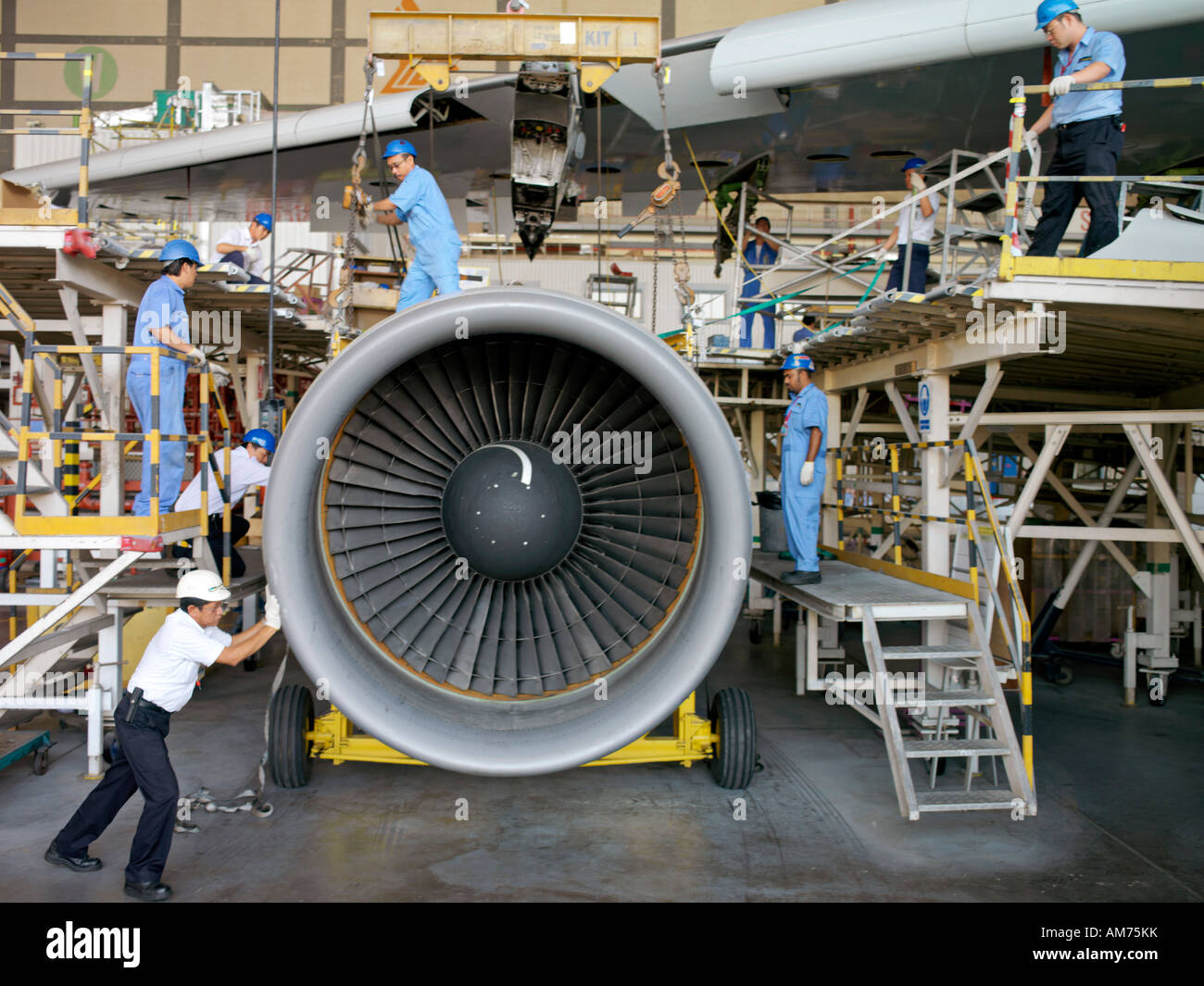Flugzeug erhält einige notwendige Wartungsarbeiten in den Aufhänger durch Arbeitnehmer Stockfoto