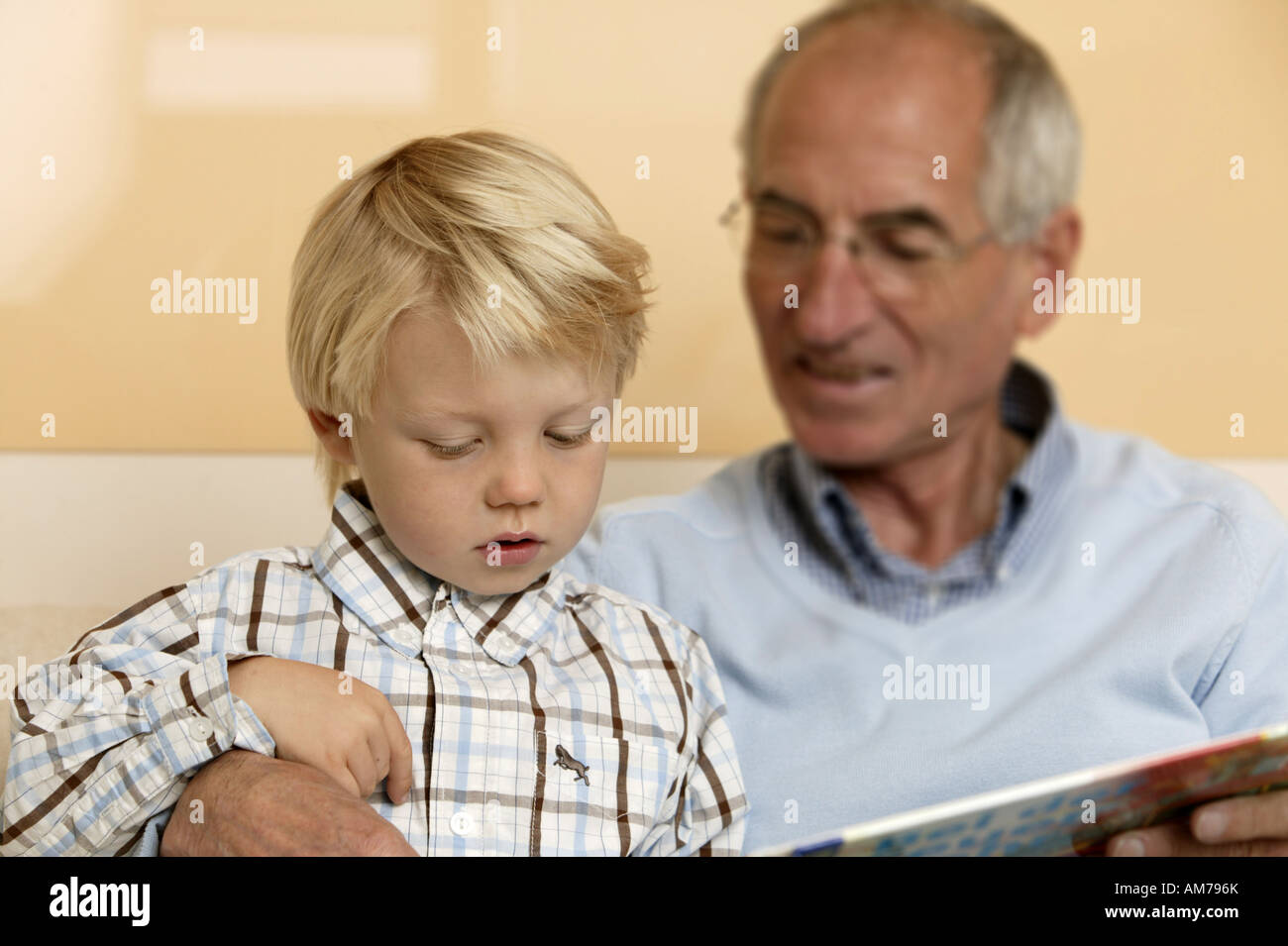Älterer Mann zu seinem Enkel aus einem Buch lesen Stockfoto
