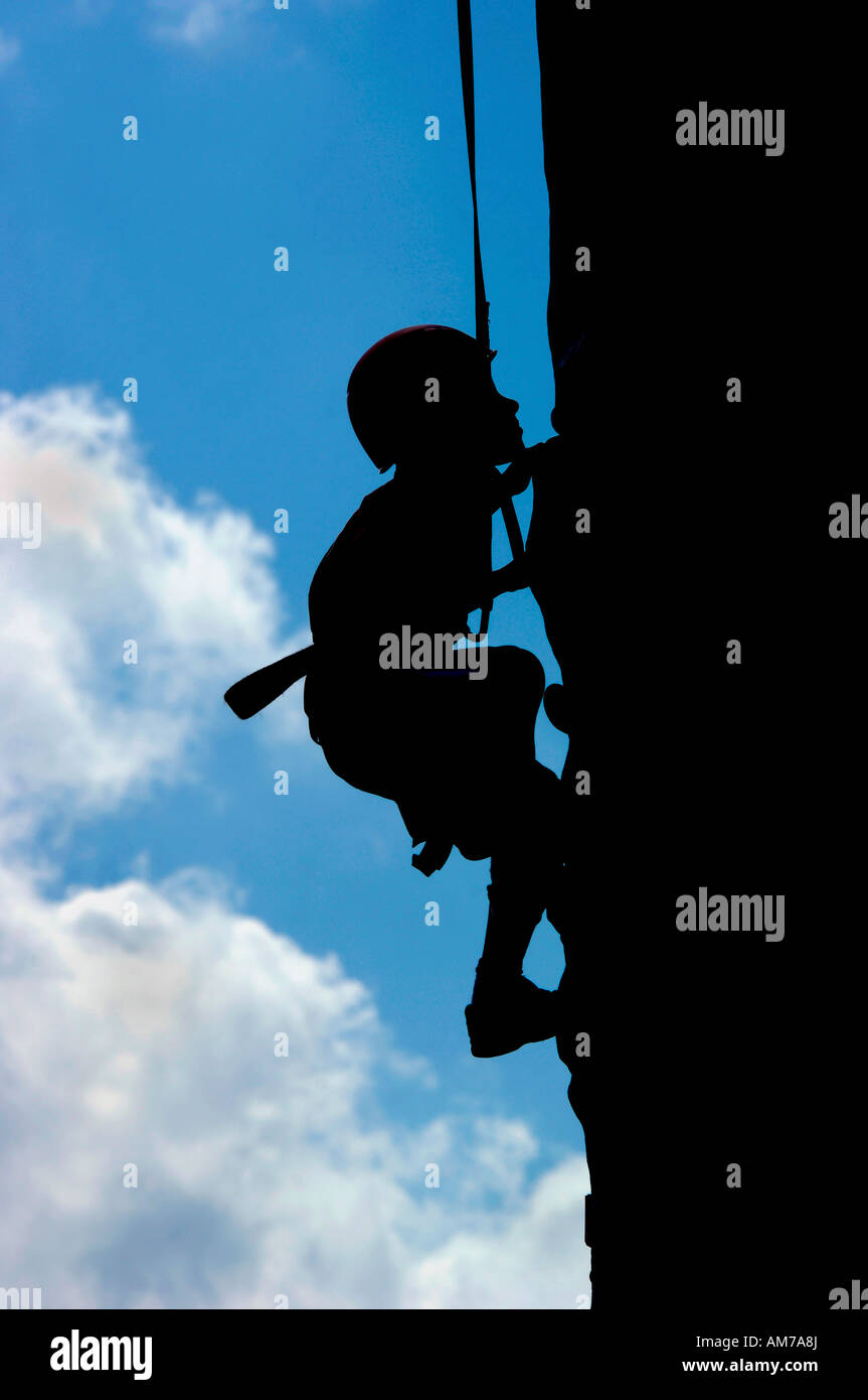 Eine Grafik Silhouette Bild eines jungen eine künstliche Felswand erklimmen. Stockfoto