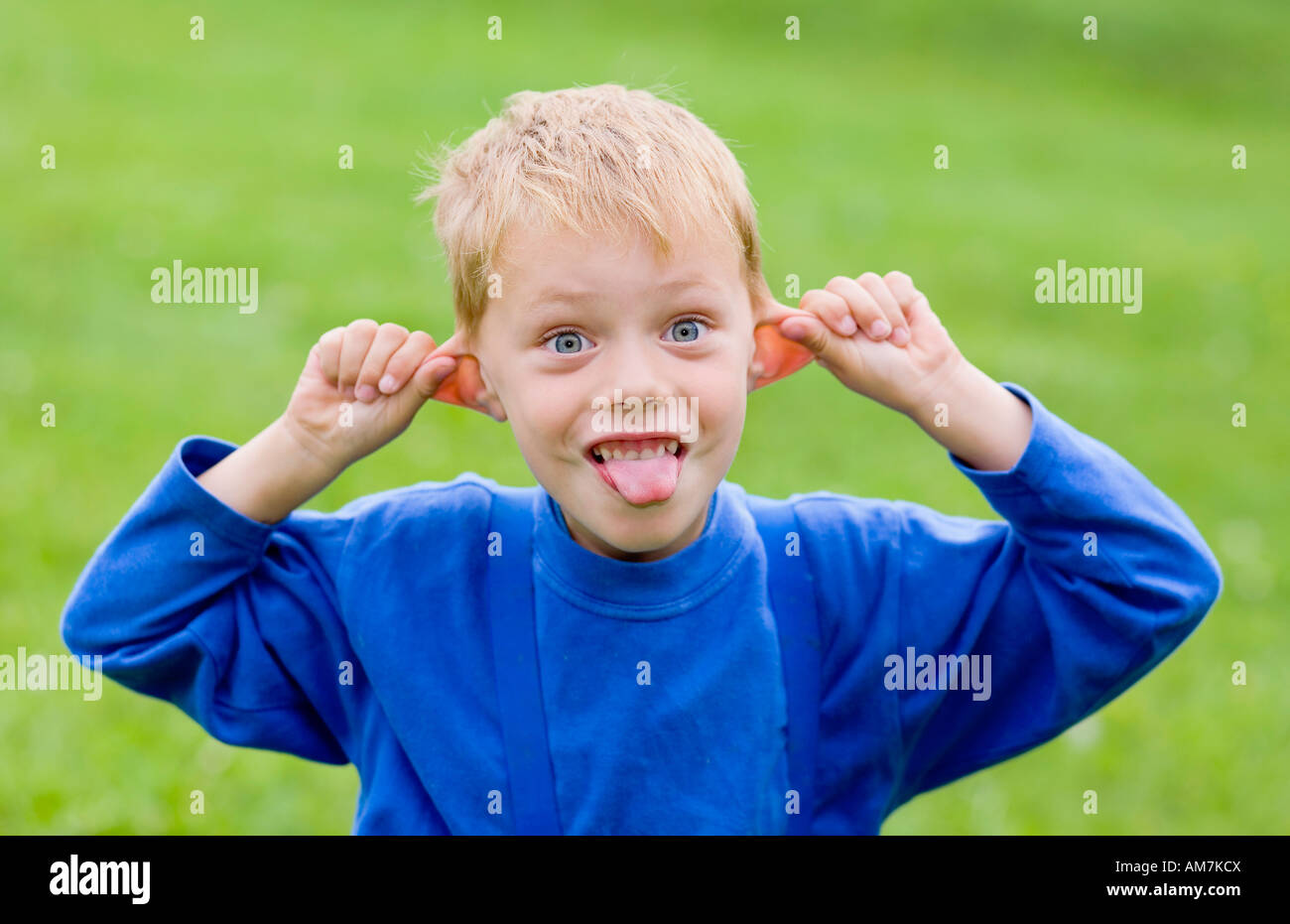 Ein Junge, 5 Jahre alt, zeigt seine Zunge Stockfoto